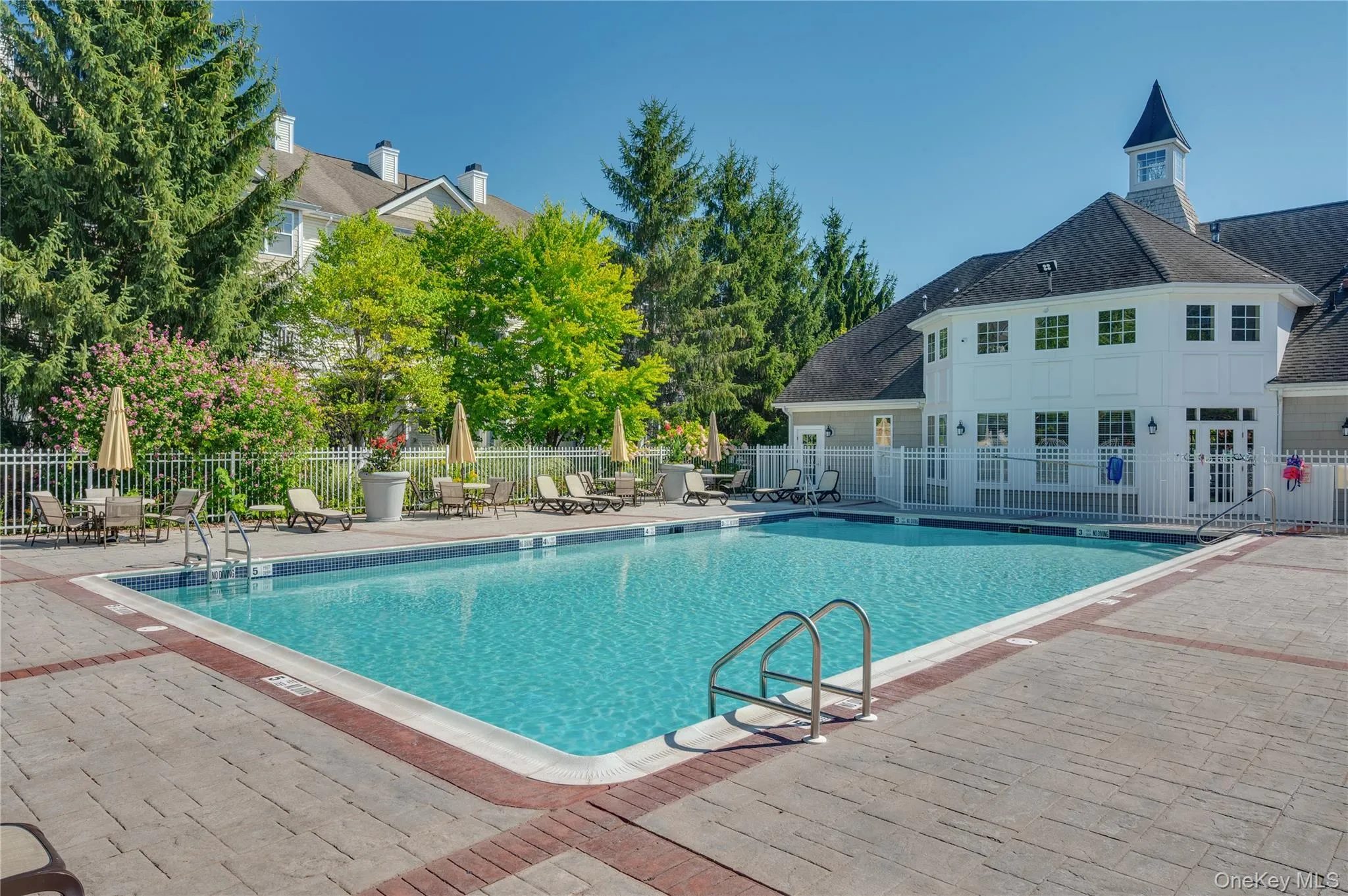 Community pool with a patio area Community pool with a patio area