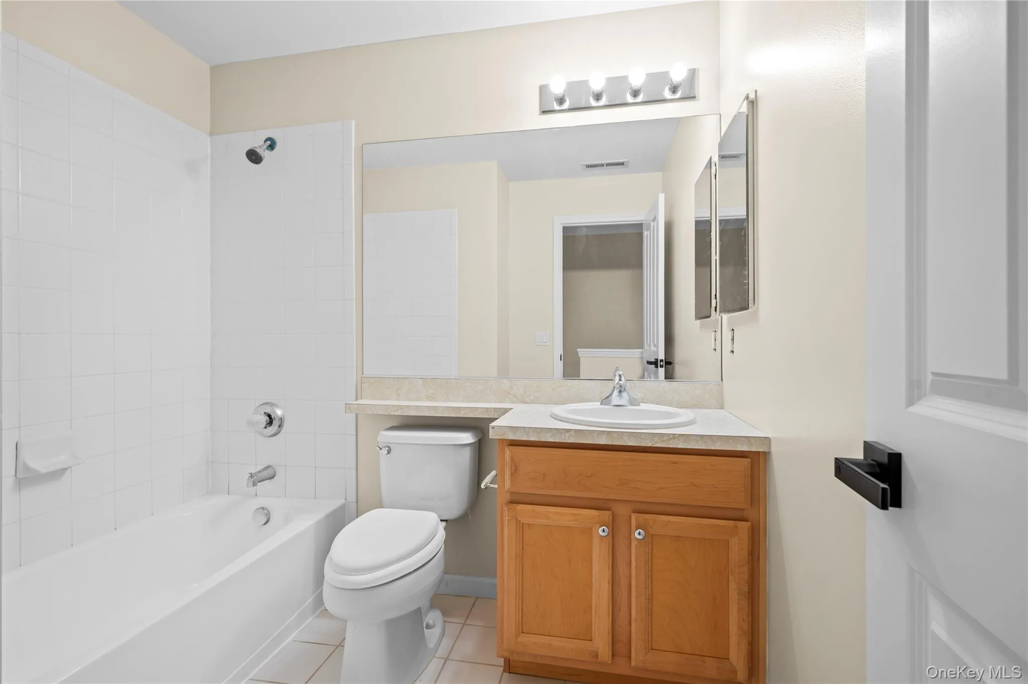 Bathroom with bathing tub / shower combination, light tile patterned floors, and vanity Bathroom with bathing tub / shower combination, light tile patterned floors, and vanity