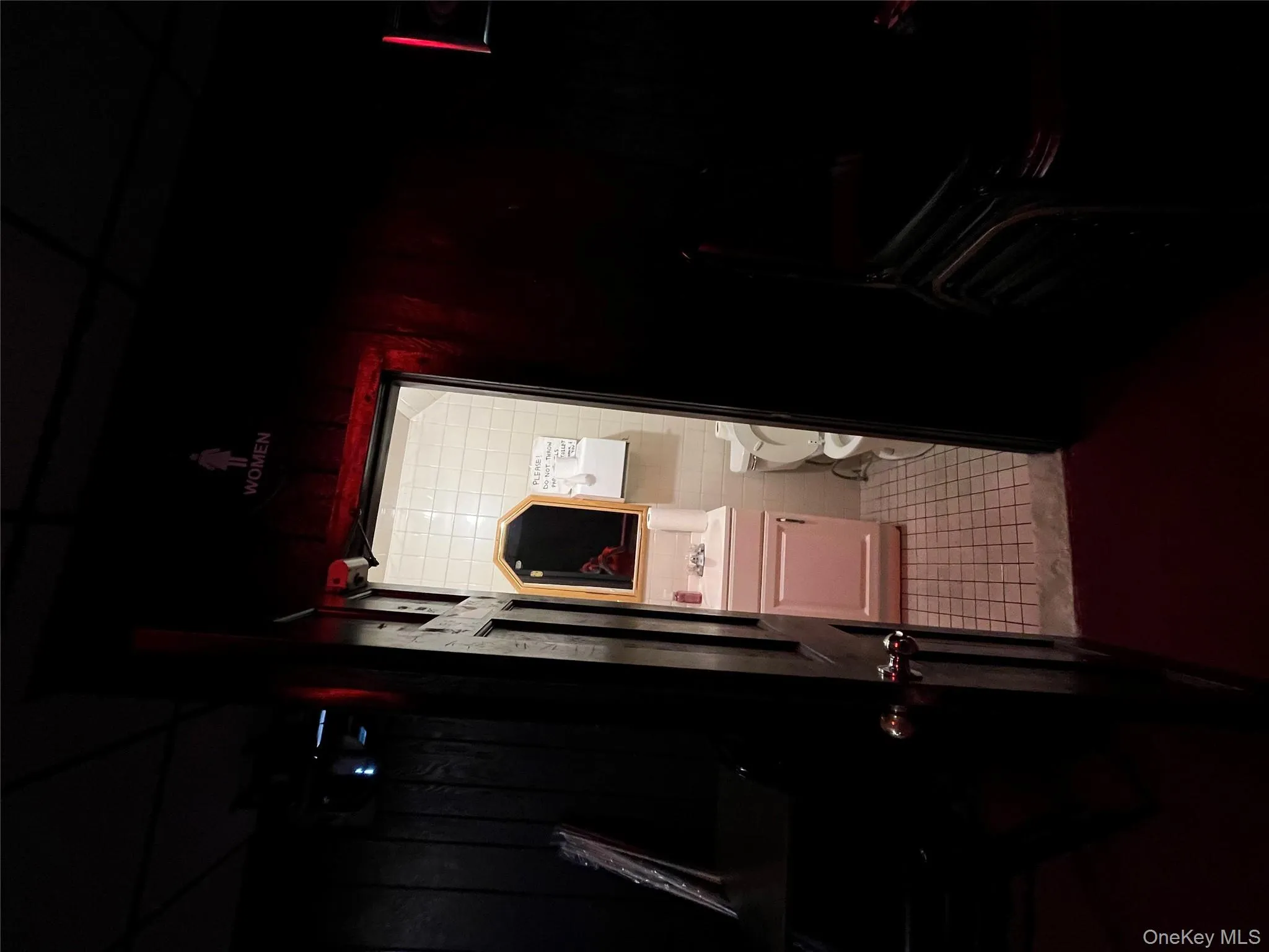 Bathroom featuring dark tile patterned floors, vanity, and tile walls Bathroom featuring dark tile patterned floors, vanity, and tile walls