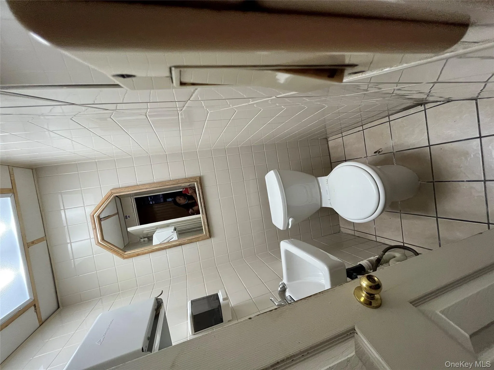 Half bathroom featuring tile walls and light tile patterned floors Half bathroom featuring tile walls and light tile patterned floors