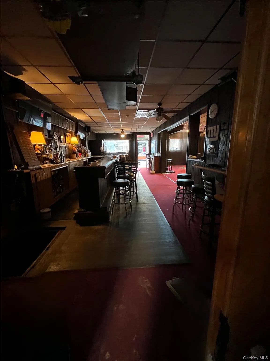 Indoor dry bar with a drop ceiling, a ceiling fan, dark cabinets, and dark countertops Indoor dry bar with a drop ceiling, a ceiling fan, dark cabinets, and dark countertops