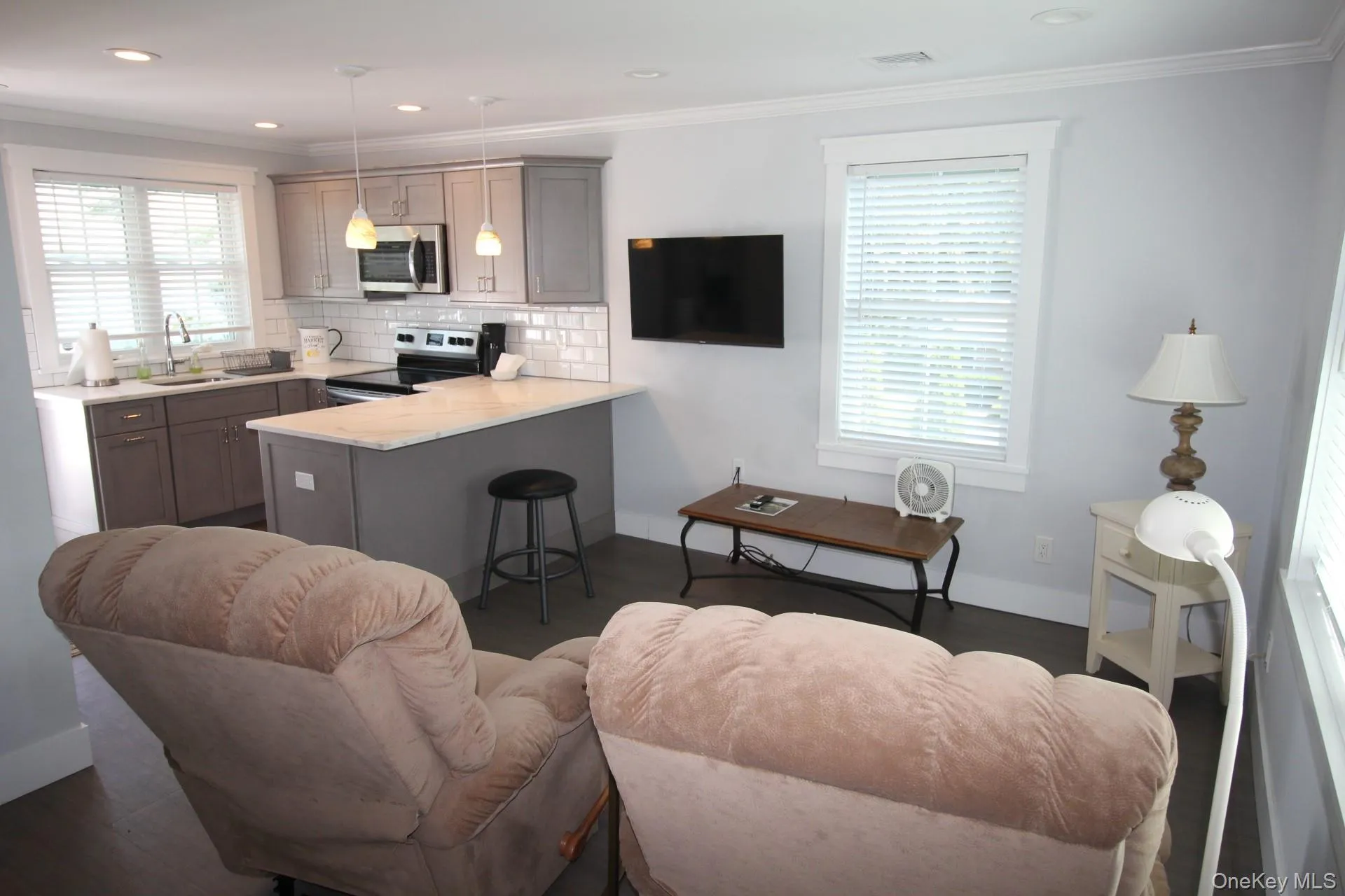 Kitchen with gray stainless steel appliances, decorative backsplash, and crown molding Kitchen with gray stainless steel appliances, decorative backsplash, and crown molding