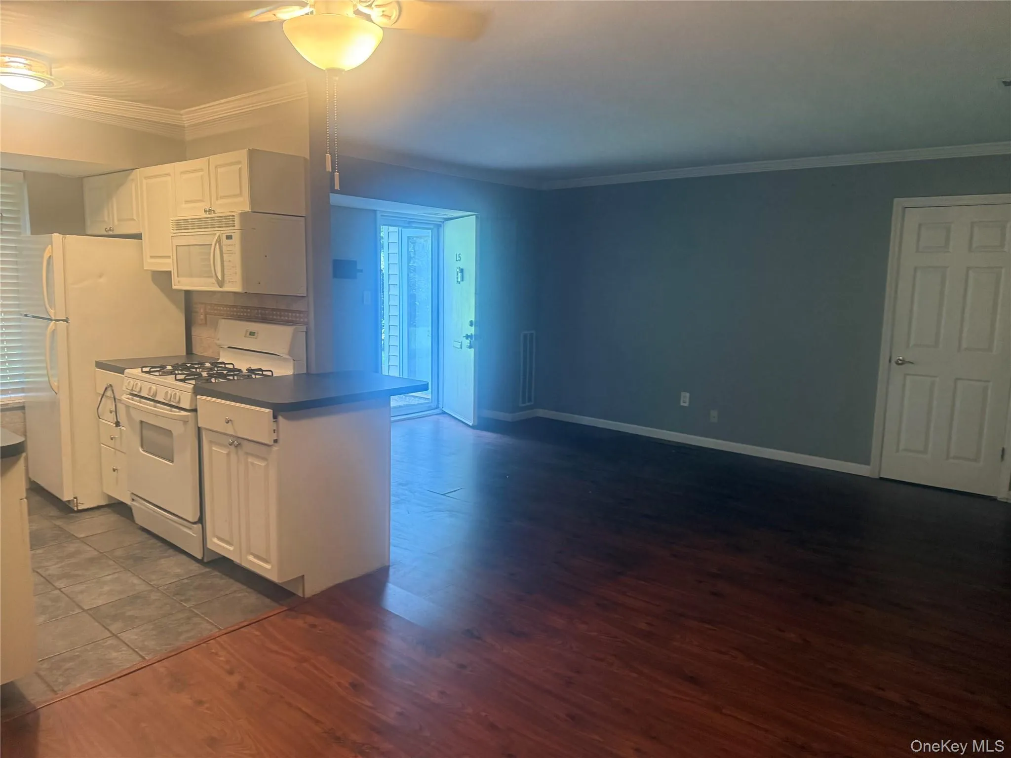 Kitchen with white cabinetry, crown molding, white gas range oven, dark wood-style floors, and ceiling fan Kitchen with white cabinetry, crown molding, white gas range oven, dark wood-style floors, and ceiling fan
