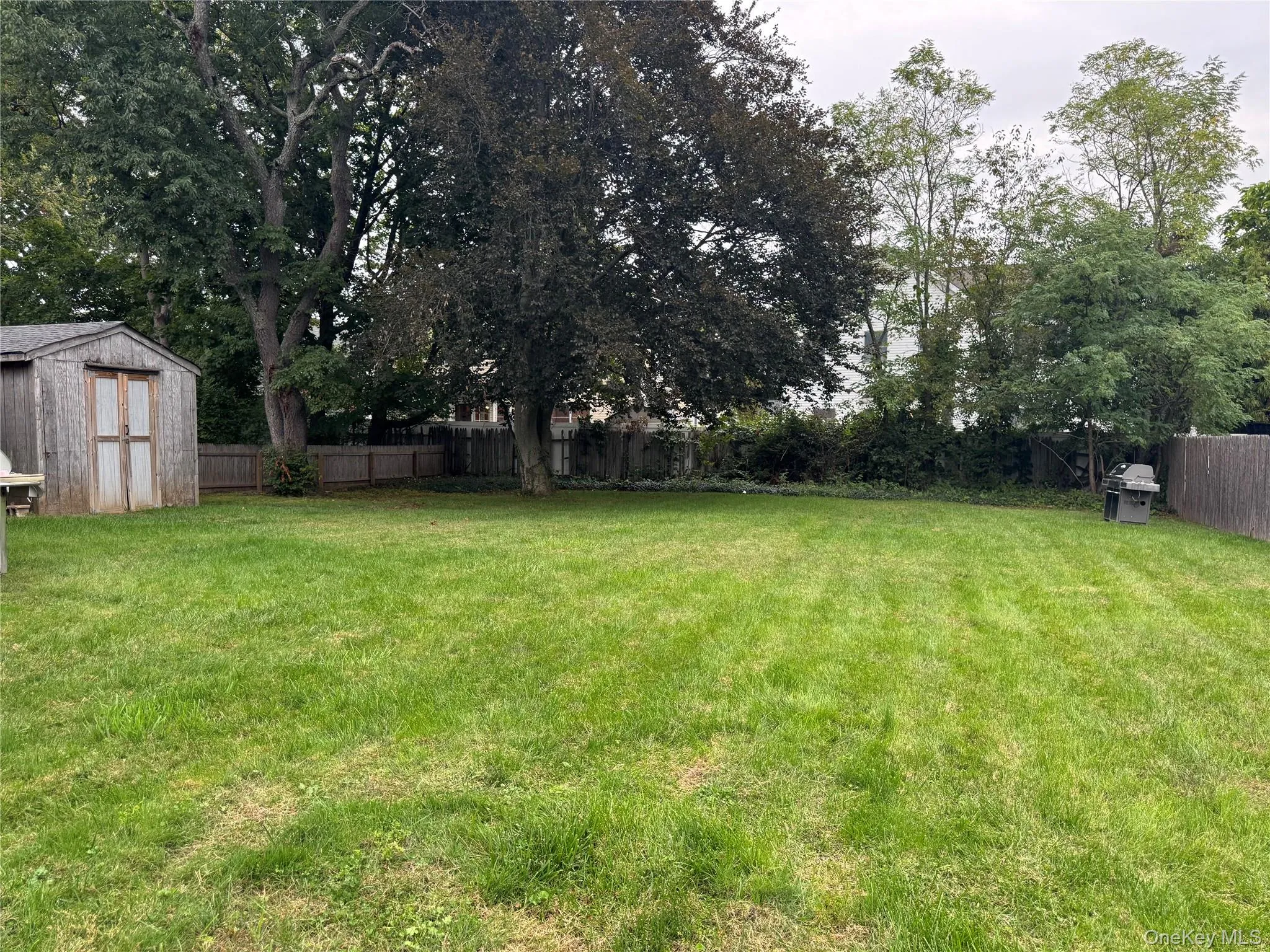 Fenced backyard with a storage shed Fenced backyard with a storage shed