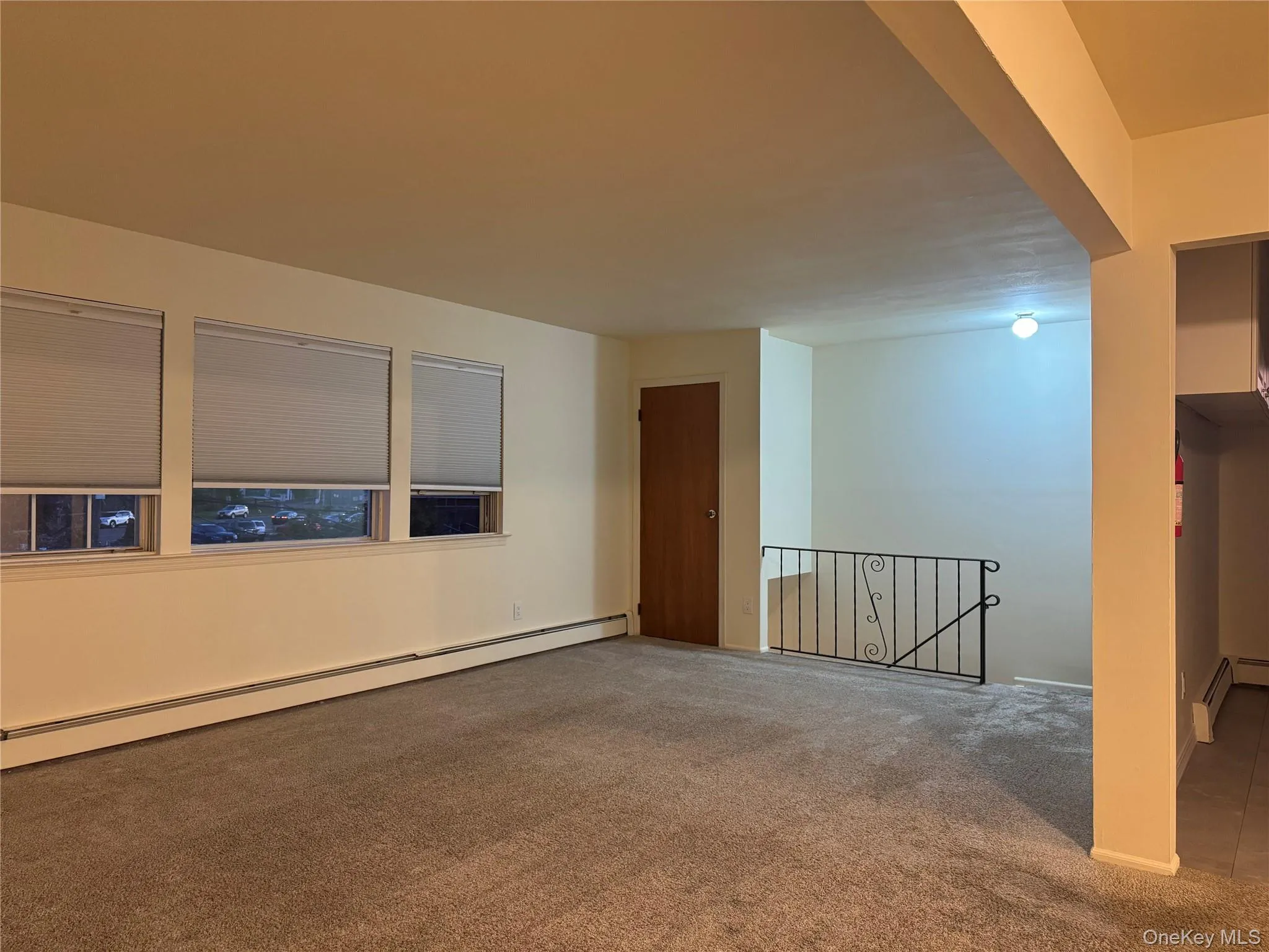 Spare room with a baseboard heating unit and carpet floors Spare room with a baseboard heating unit and carpet floors