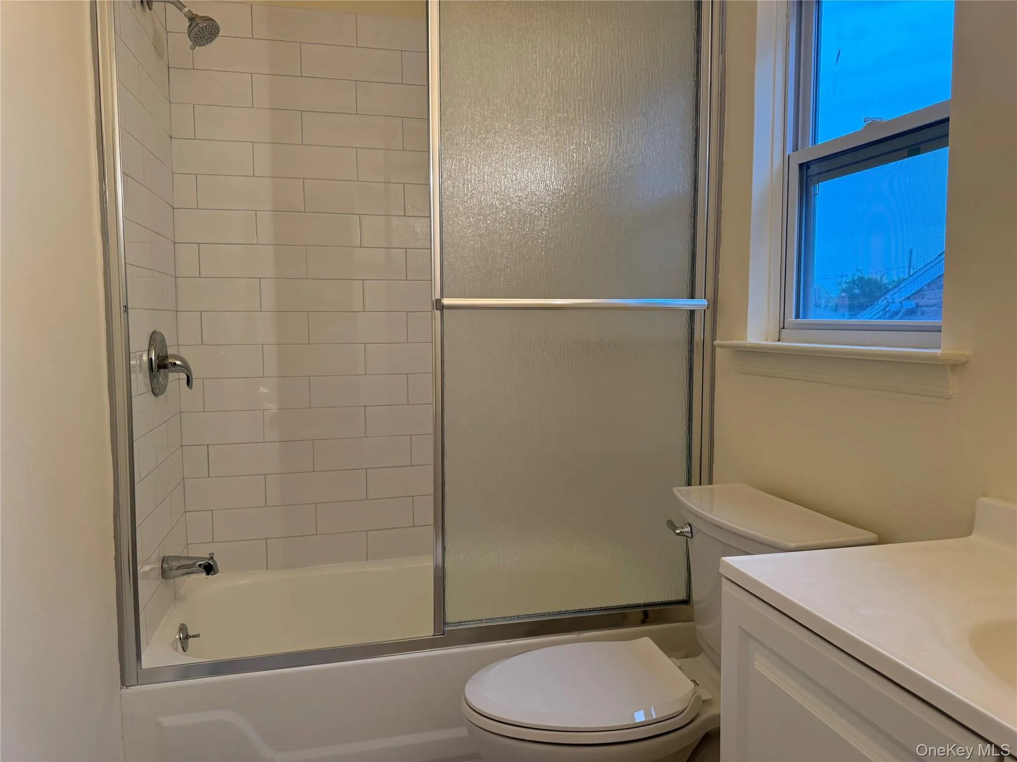 Full bathroom featuring bath / shower combo with glass door and vanity Full bathroom featuring bath / shower combo with glass door and vanity