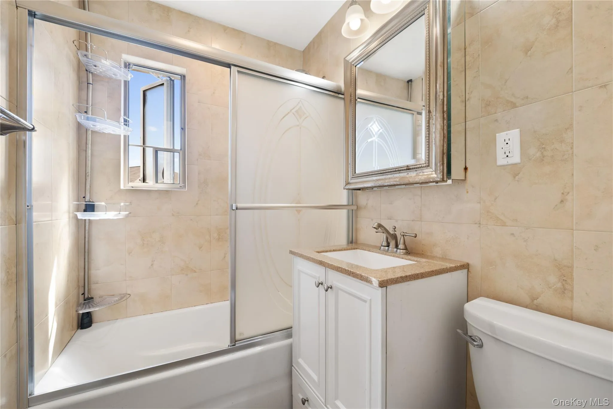 Bathroom with tile walls, enclosed tub / shower combo, and vanity Bathroom with tile walls, enclosed tub / shower combo, and vanity