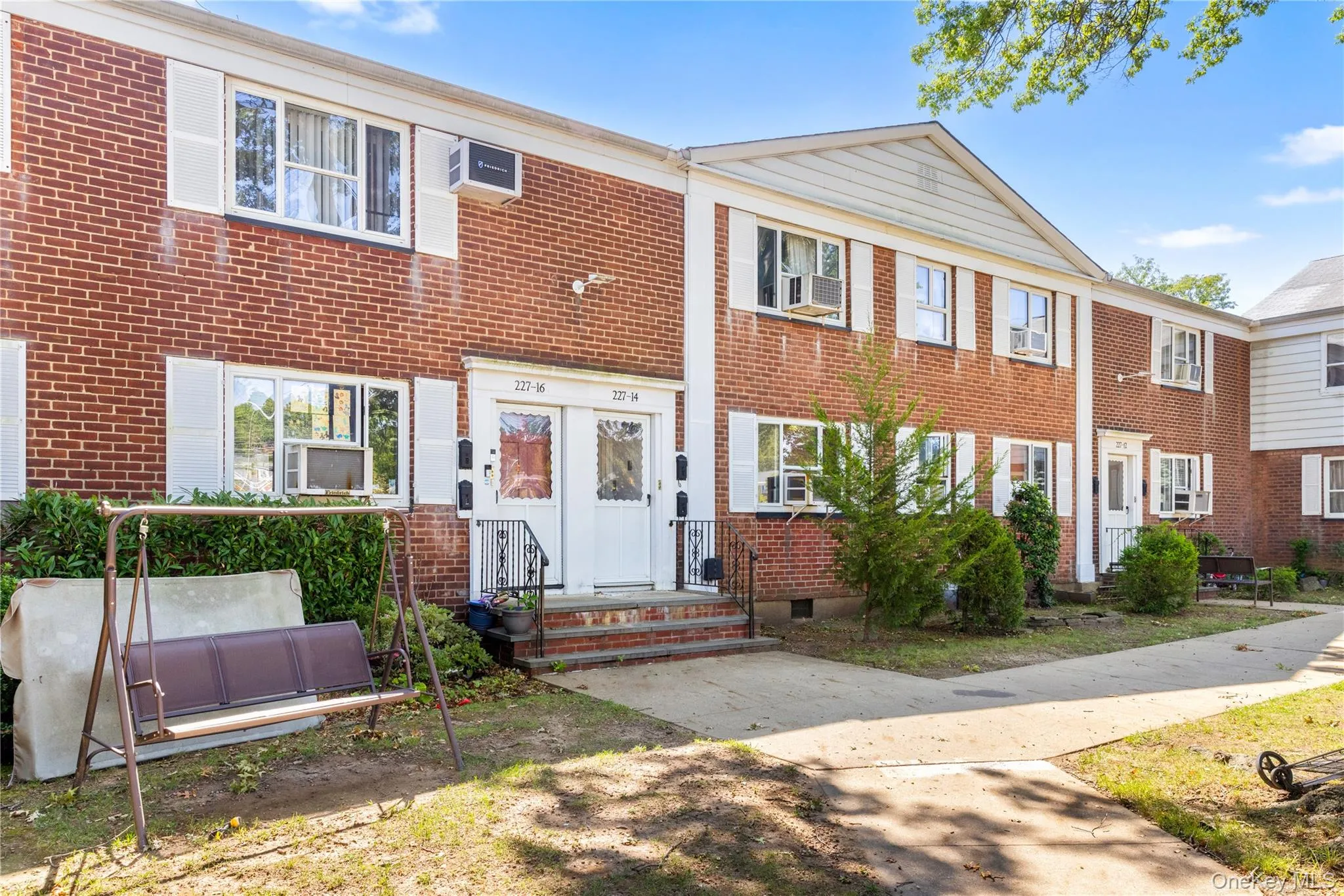 View of front of property with brick siding and a wall mounted AC View of front of property with brick siding and a wall mounted AC