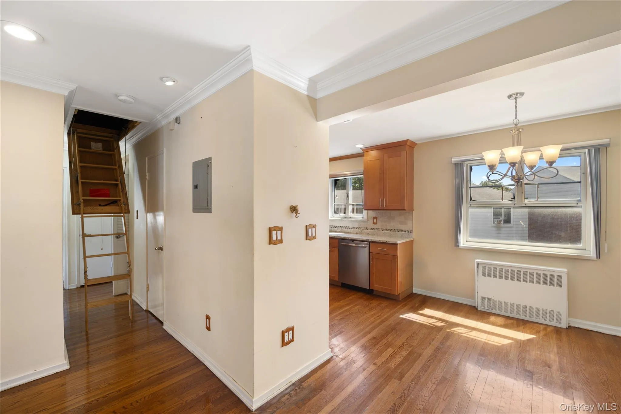 Kitchen with brown cabinets, radiator heating unit, dark wood-style flooring, ornamental molding, and pendant lighting Kitchen with brown cabinets, radiator heating unit, dark wood-style flooring, ornamental molding, and pendant lighting