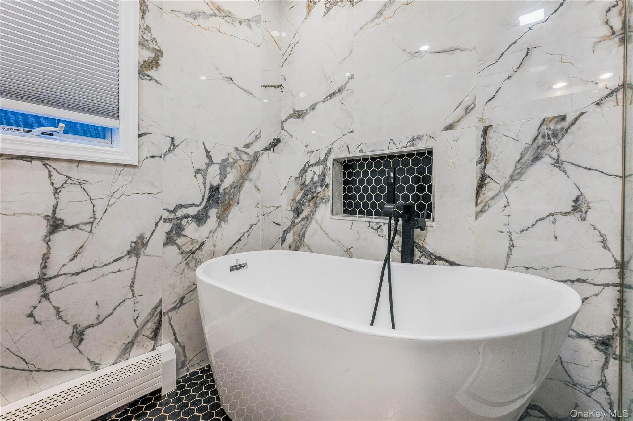 Full bath with baseboard heating, a soaking tub, and stone wall Full bath with baseboard heating, a soaking tub, and stone wall