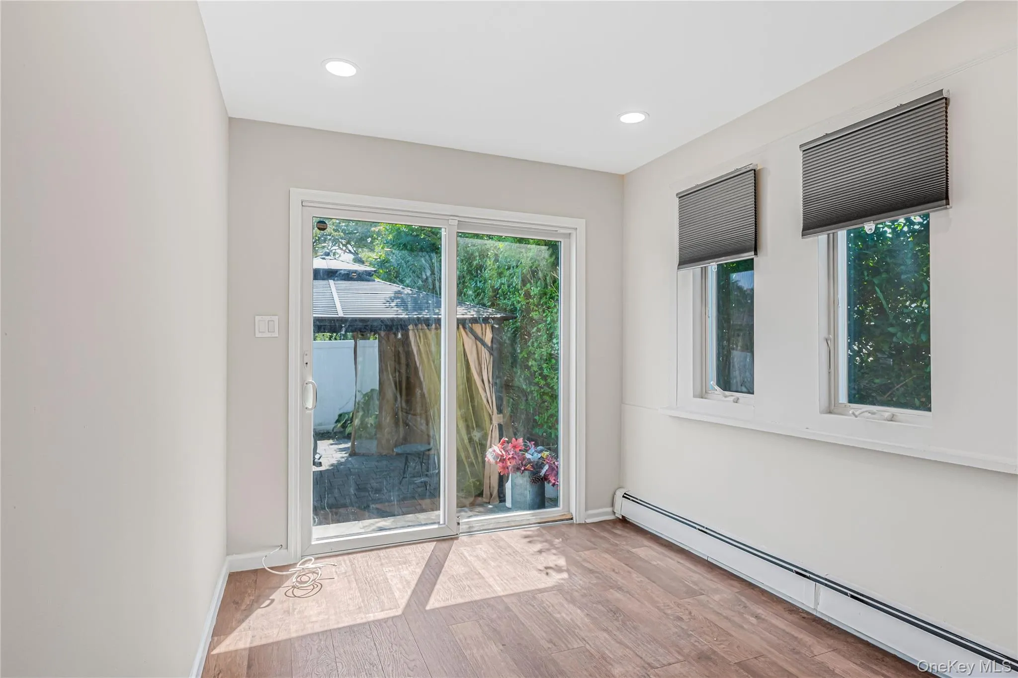 Spare room with a baseboard heating unit, light wood finished floors, and recessed lighting Spare room with a baseboard heating unit, light wood finished floors, and recessed lighting