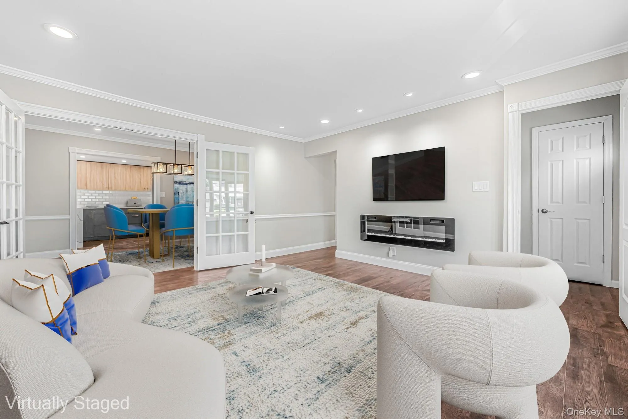 Living area featuring wood finished floors, ornamental molding, french doors, and recessed lighting Living area featuring wood finished floors, ornamental molding, french doors, and recessed lighting