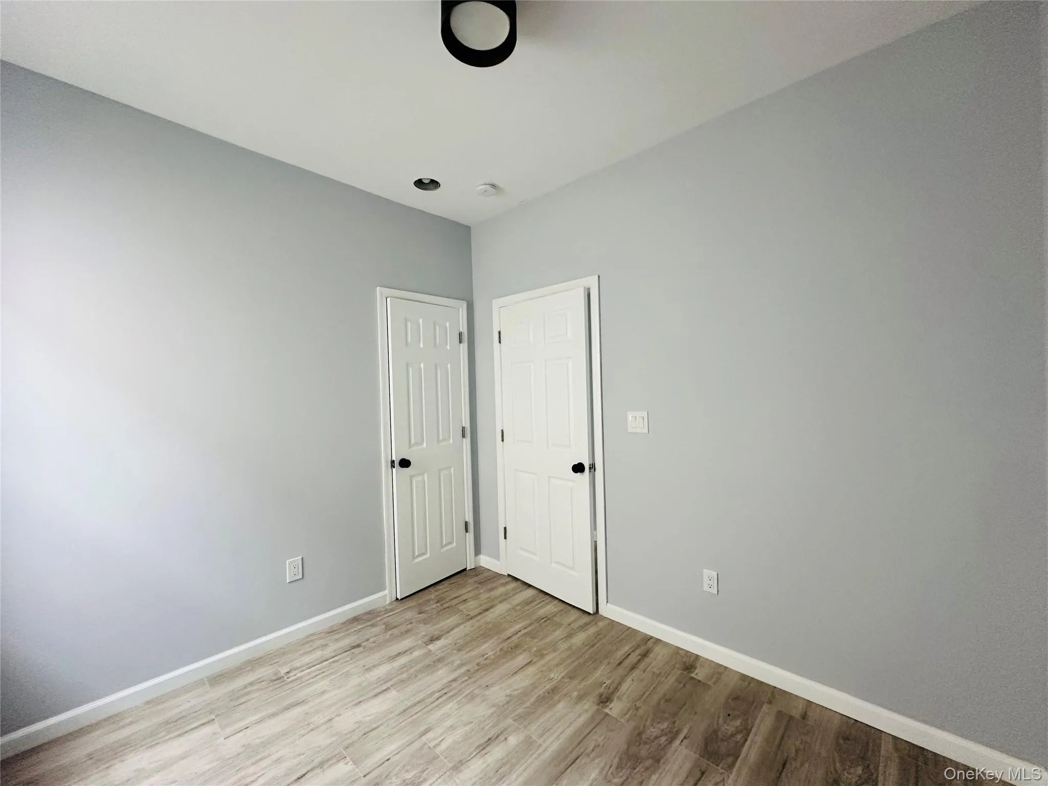 Empty room featuring light wood-style floors and baseboards Empty room featuring light wood-style floors and baseboards