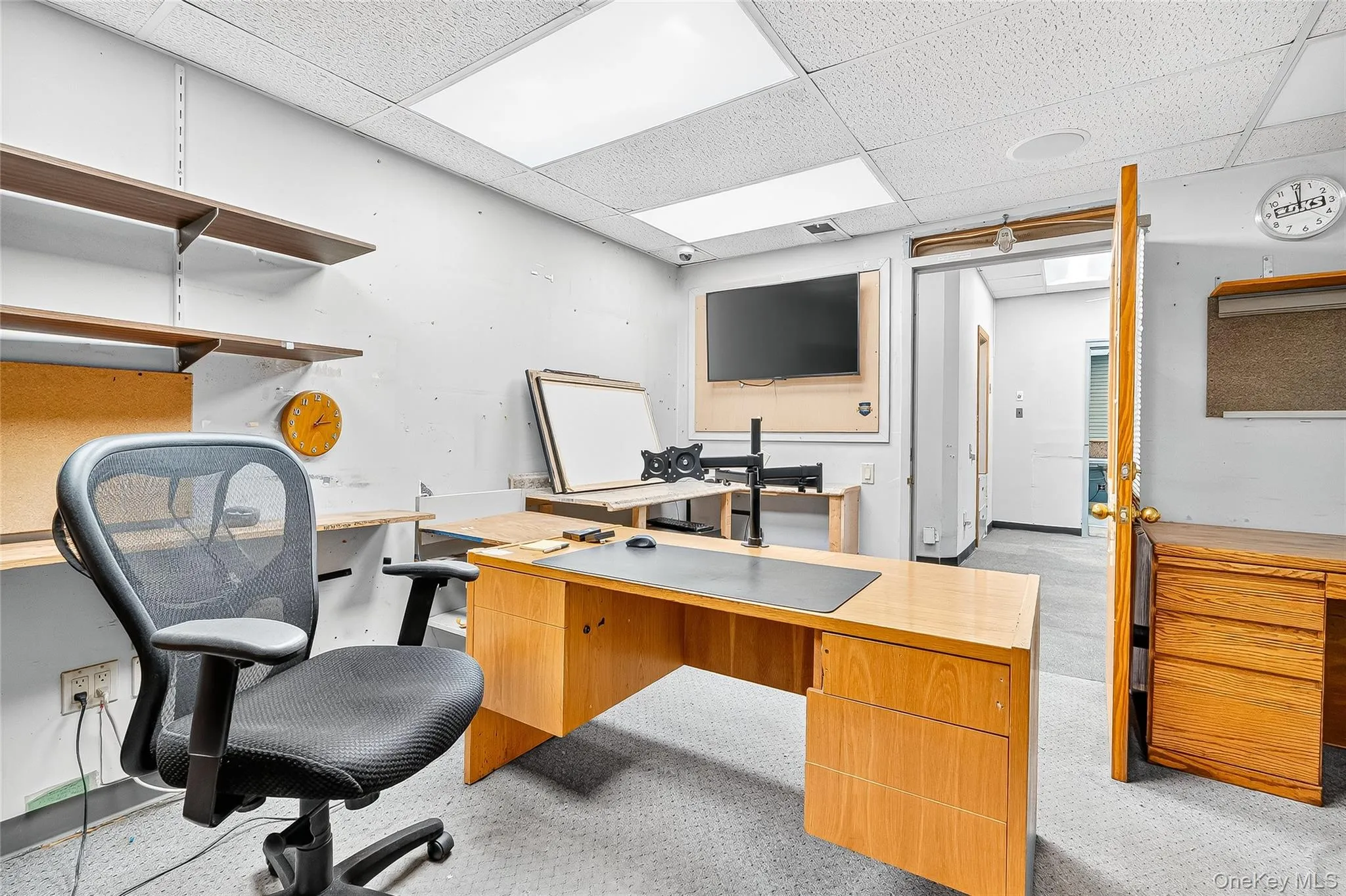 Office area featuring a drop ceiling and light carpet Office area featuring a drop ceiling and light carpet