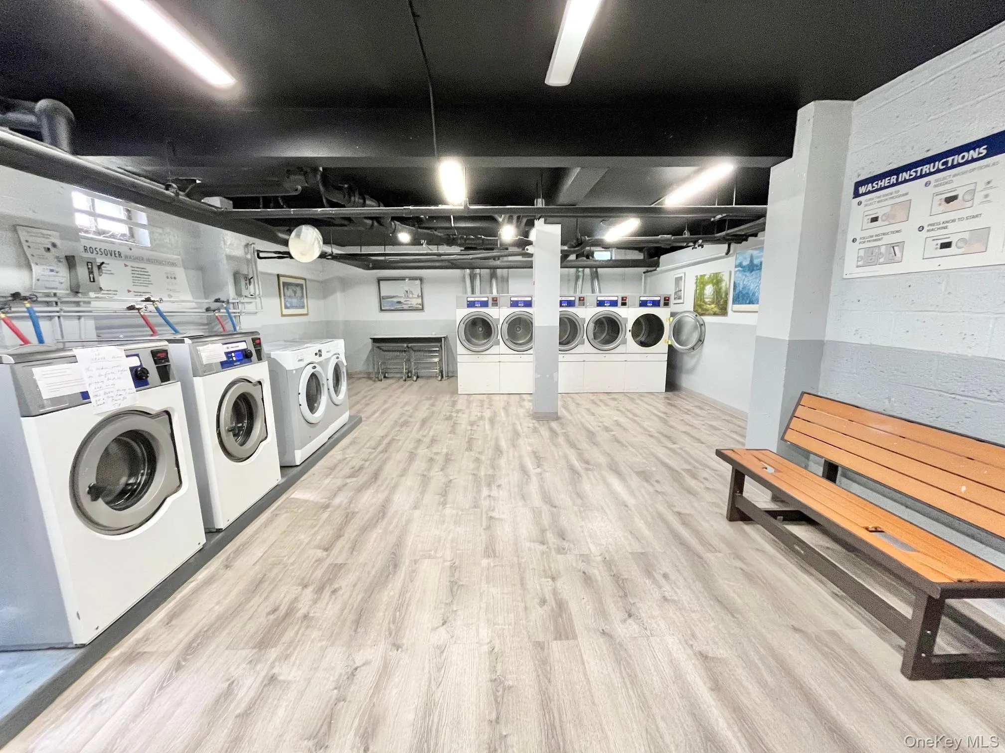 Shared laundry featuring washer and dryer and light wood-style floors Shared laundry featuring washer and dryer and light wood-style floors