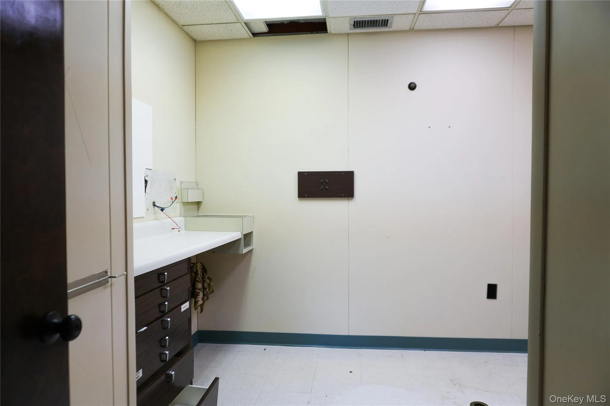Bathroom featuring a drop ceiling and light flooring Bathroom featuring a drop ceiling and light flooring