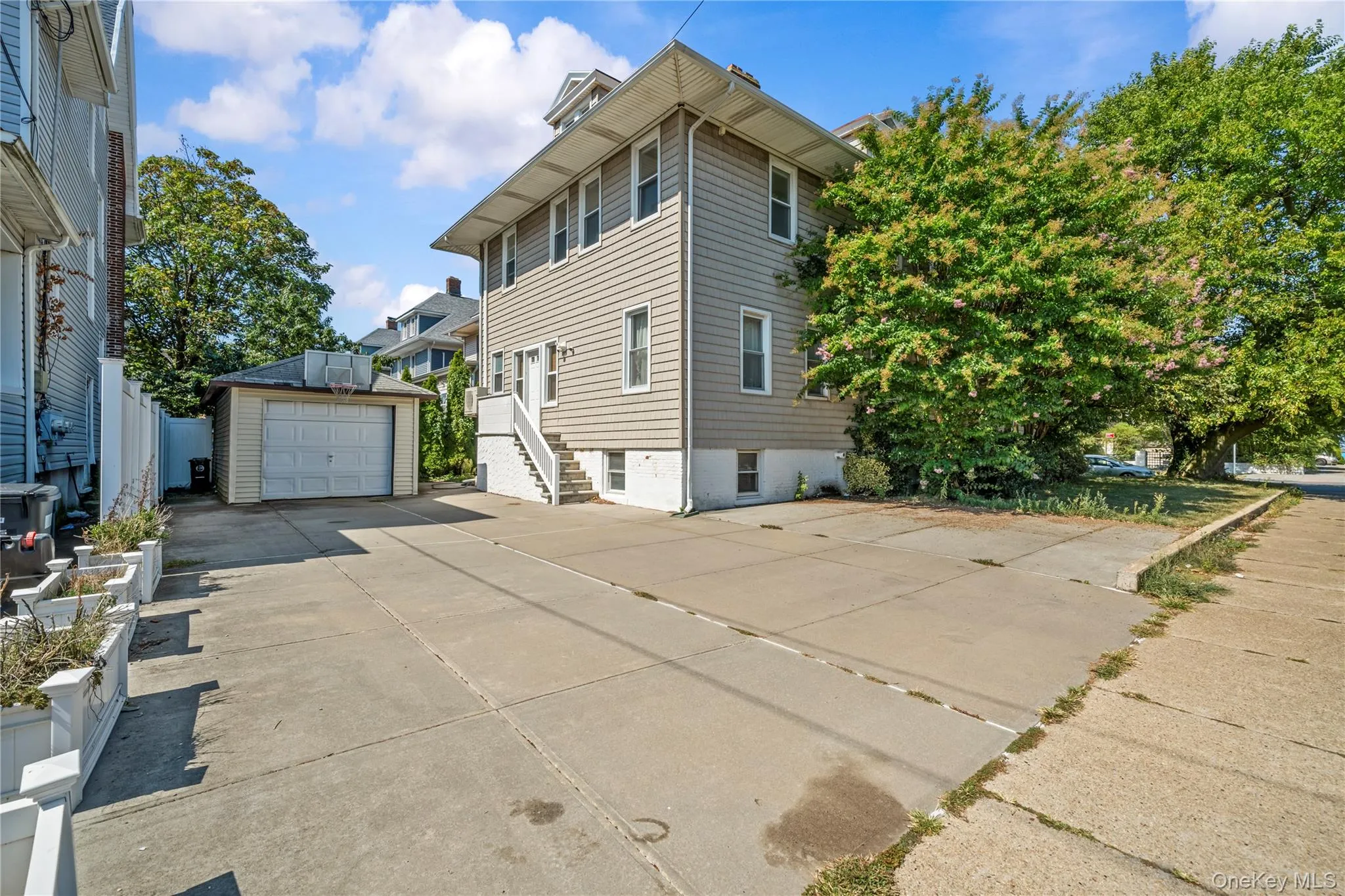 View of side of home with driveway, an outbuilding, a detached garage, and stairway View of side of home with driveway, an outbuilding, a detached garage, and stairway