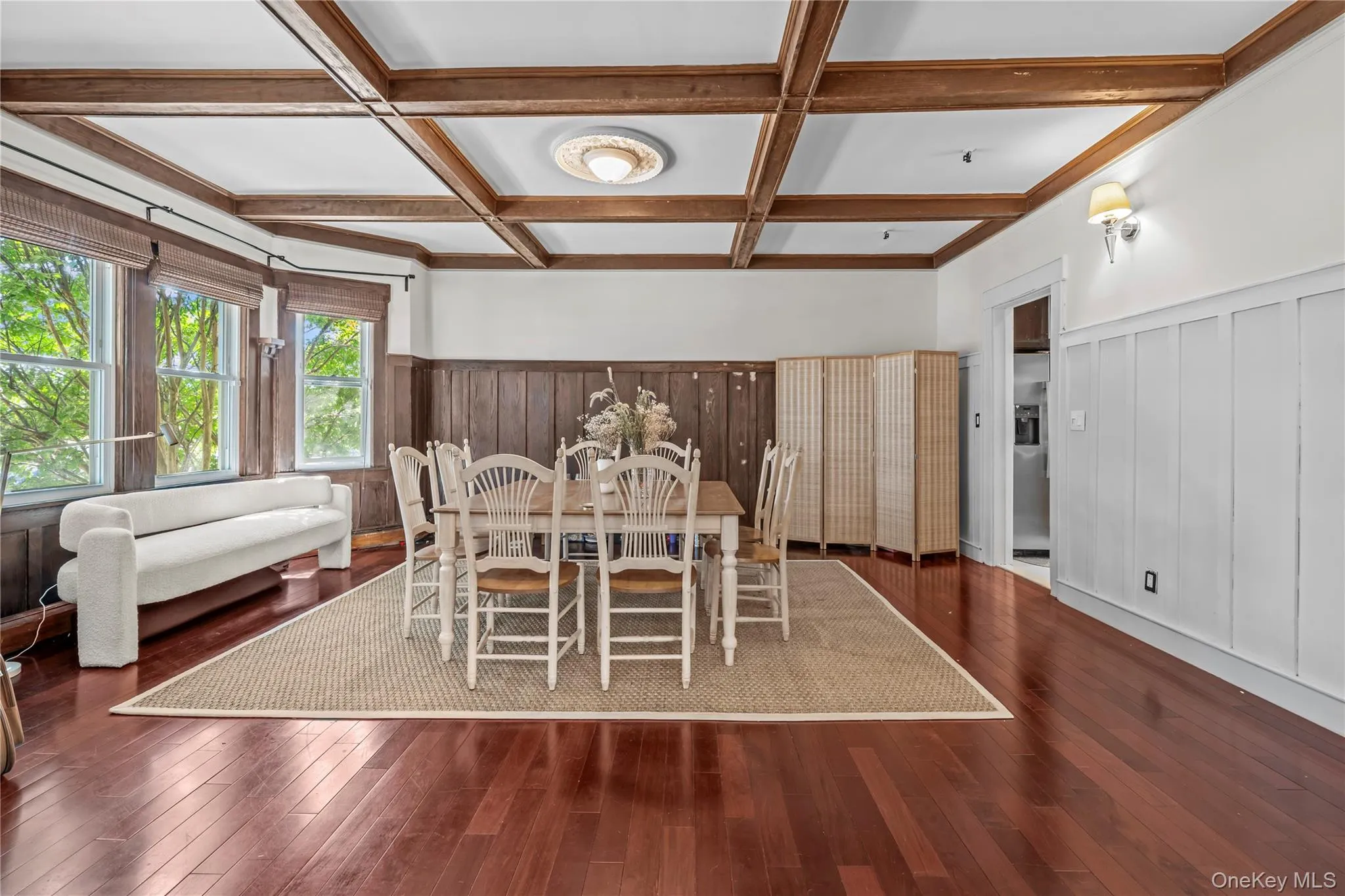 Dining space with coffered ceiling, beamed ceiling, a wainscoted wall, and dark wood-type flooring Dining space with coffered ceiling, beamed ceiling, a wainscoted wall, and dark wood-type flooring