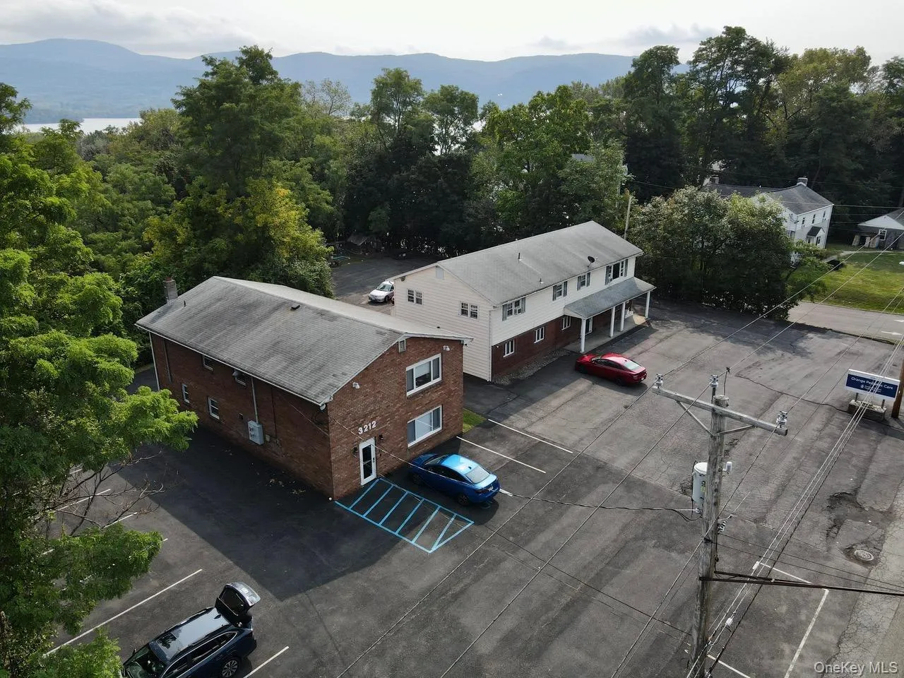 Aerial view of property and surrounding area with a mountain backdrop. Aerial view of property and surrounding area with a mountain backdrop.