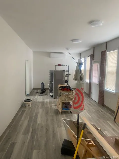 Workout room with wood finished floors and a wall unit AC Workout room with wood finished floors and a wall unit AC