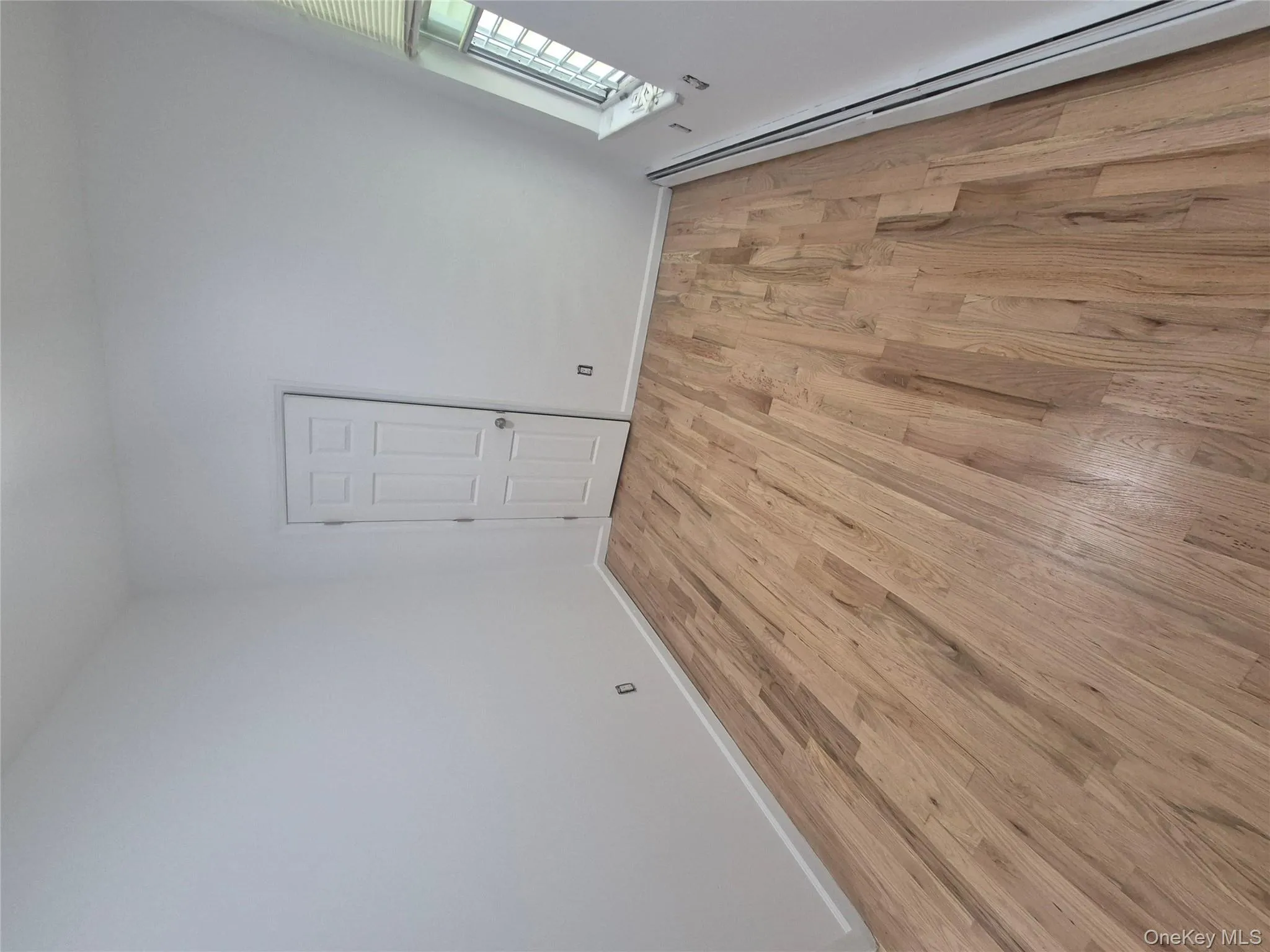 Spare room with a baseboard radiator and light wood-style floors Spare room with a baseboard radiator and light wood-style floors