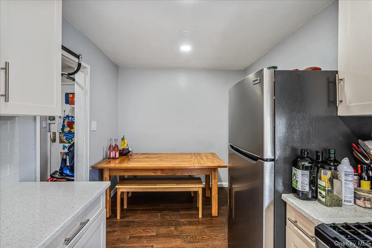 Kitchen featuring white cabinets, dark wood finished floors, and light stone countertops Kitchen featuring white cabinets, dark wood finished floors, and light stone countertops