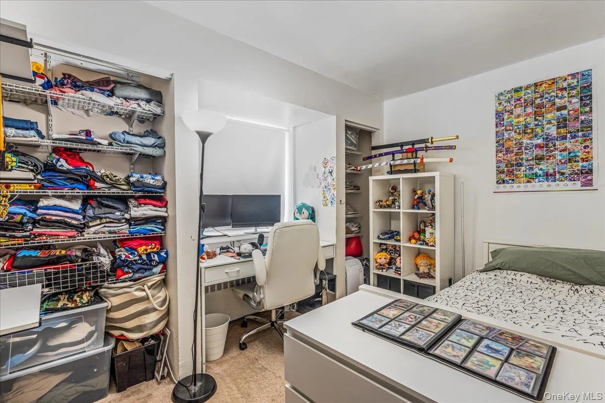 Bedroom with a desk and light colored carpet Bedroom with a desk and light colored carpet