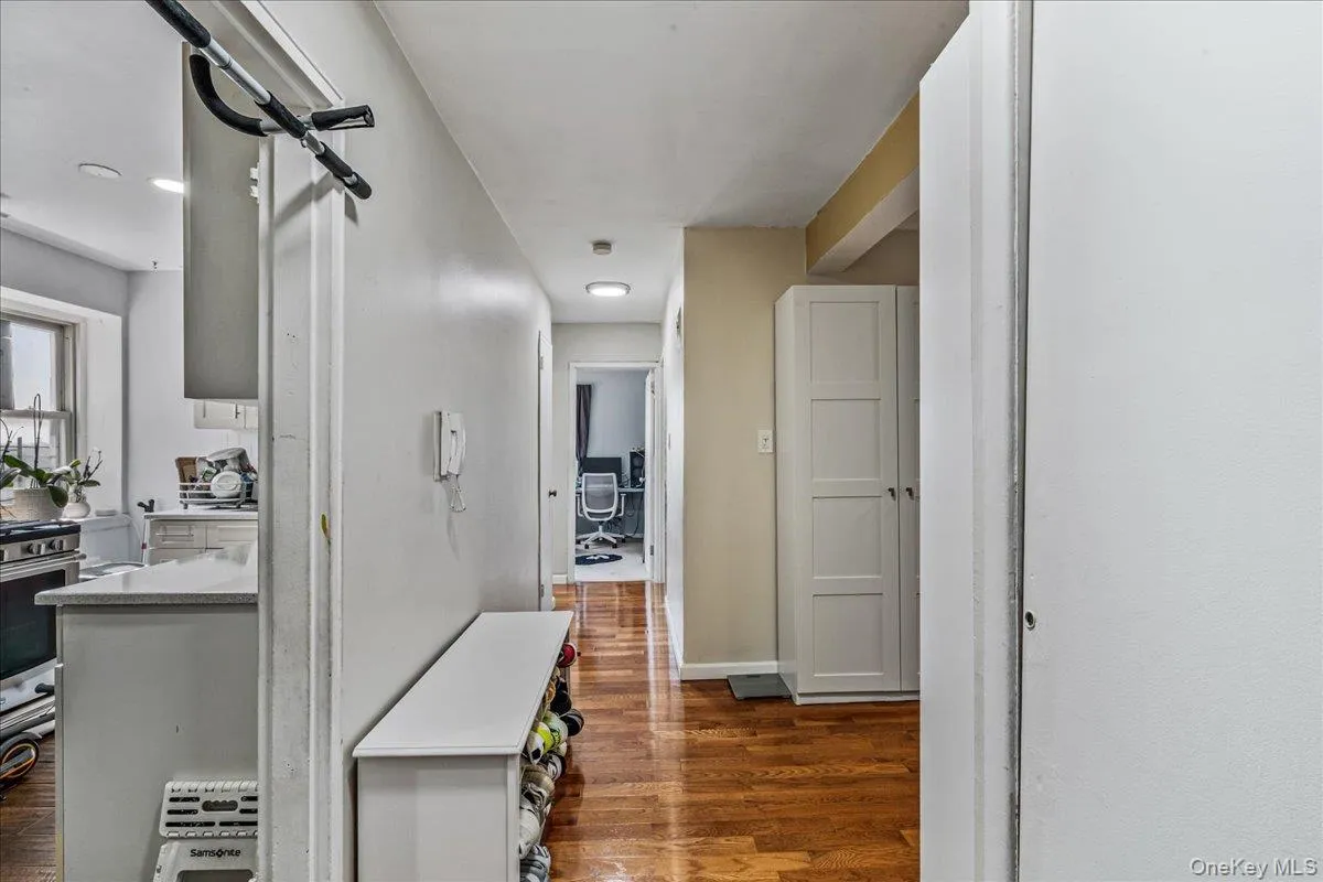 Hall with dark wood-type flooring and baseboards Hall with dark wood-type flooring and baseboards