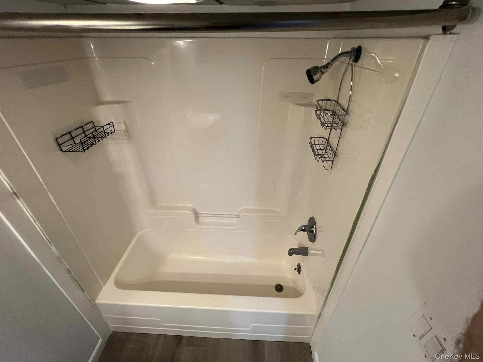 Full bath with tub / shower combination and wood finished floors Full bath with tub / shower combination and wood finished floors