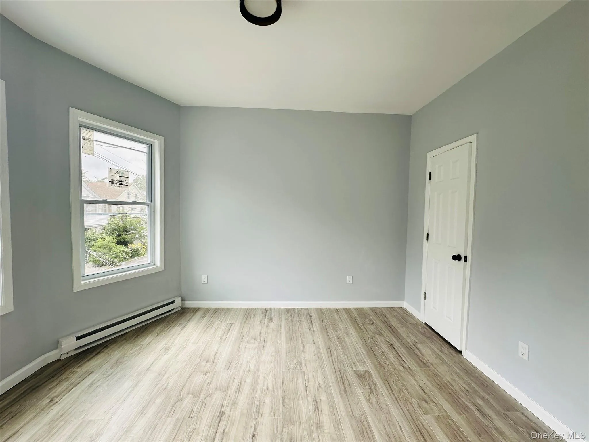 Spare room with a baseboard radiator and light wood finished floors Spare room with a baseboard radiator and light wood finished floors