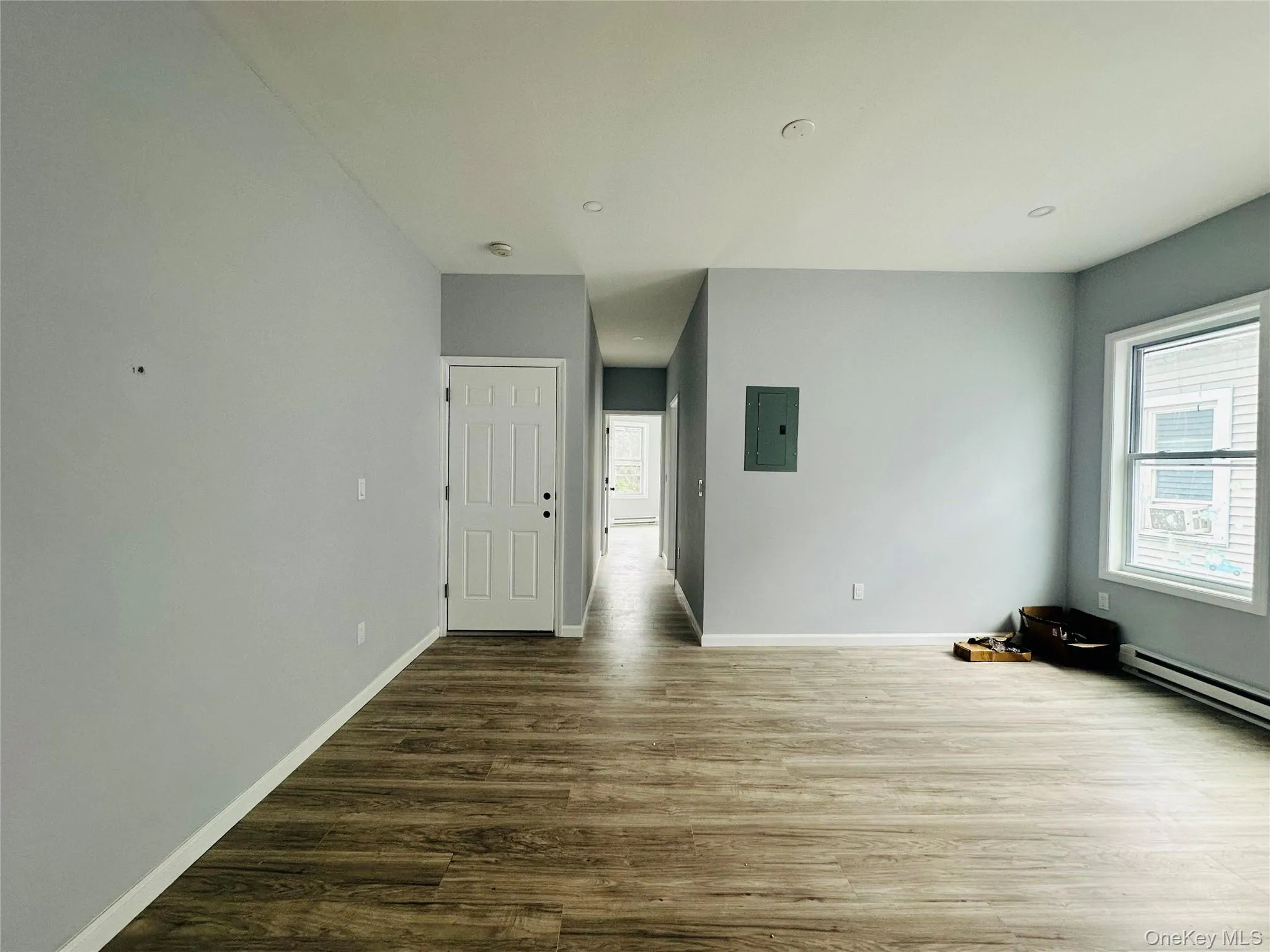 Empty room featuring dark wood-style floors and electric panel Empty room featuring dark wood-style floors and electric panel