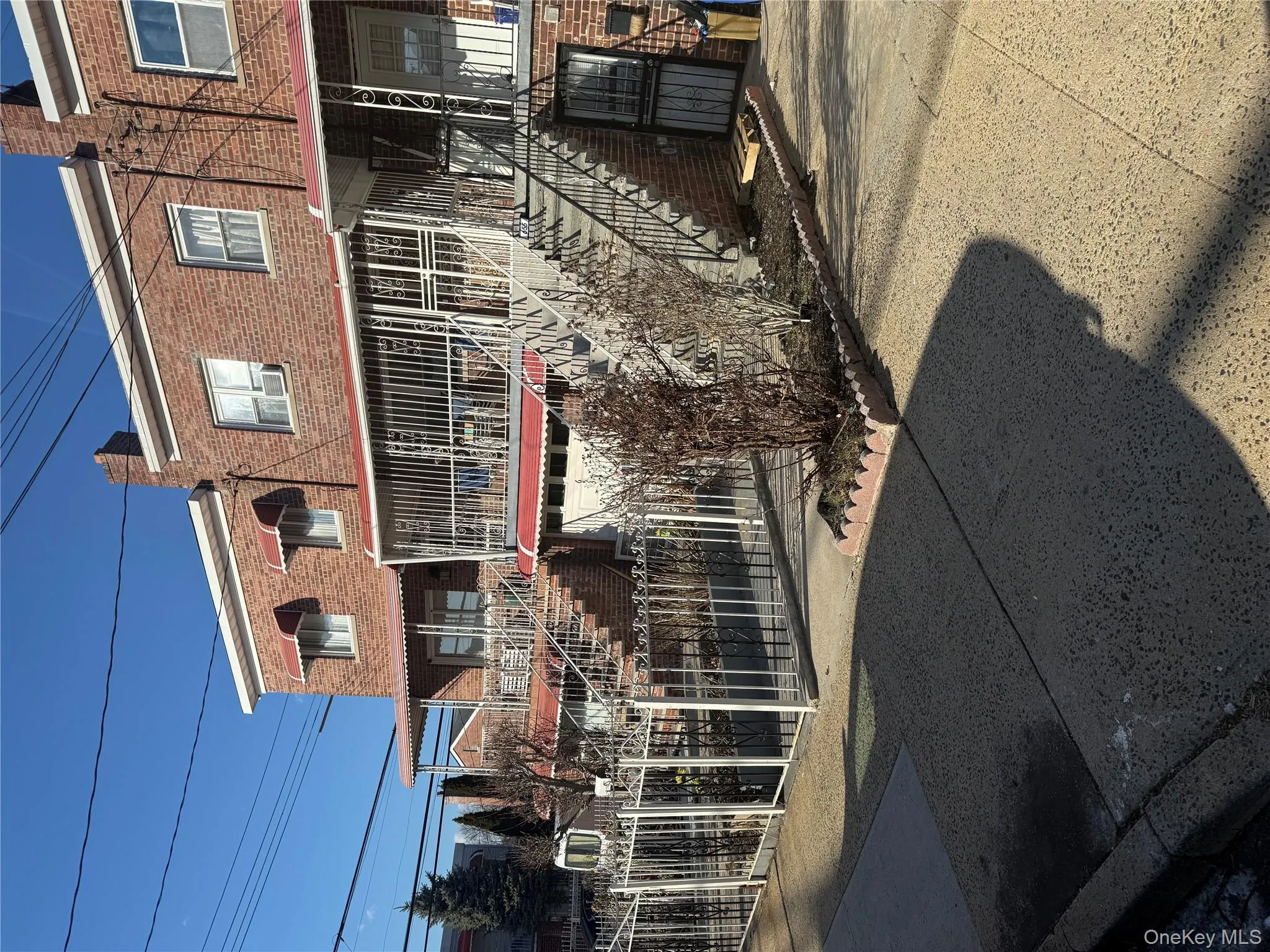 View of property featuring stairway, fence, brick siding, and a chimney View of property featuring stairway, fence, brick siding, and a chimney