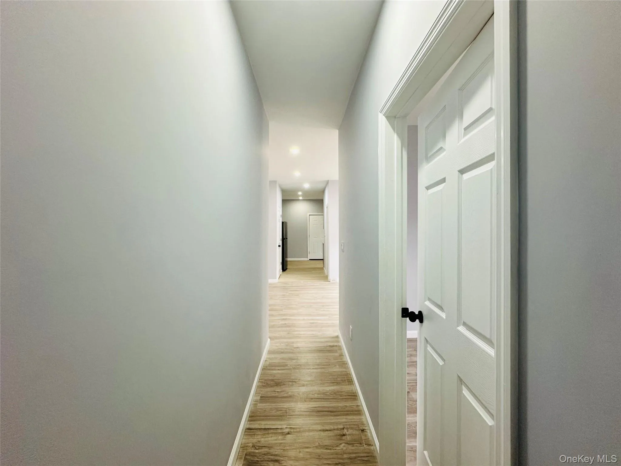 Hallway featuring light wood-style floors and recessed lighting Hallway featuring light wood-style floors and recessed lighting