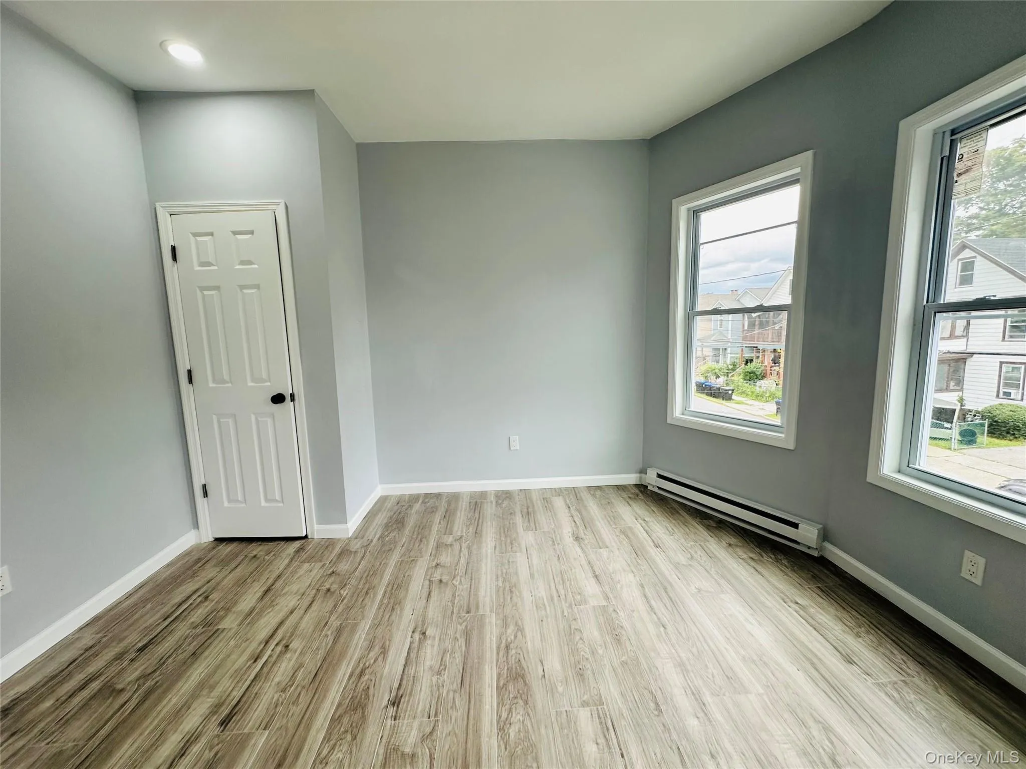 Unfurnished room featuring a baseboard radiator and light wood-style floors Unfurnished room featuring a baseboard radiator and light wood-style floors