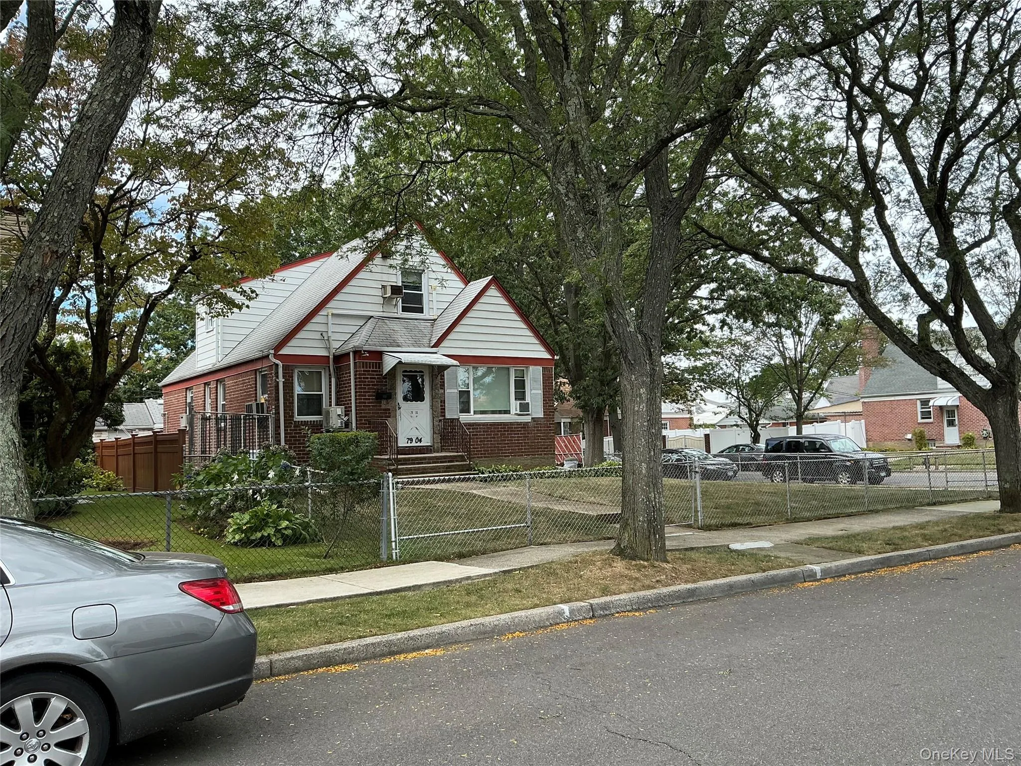 Cape cod-style home with brick siding and a fenced front yard Cape cod-style home with brick siding and a fenced front yard