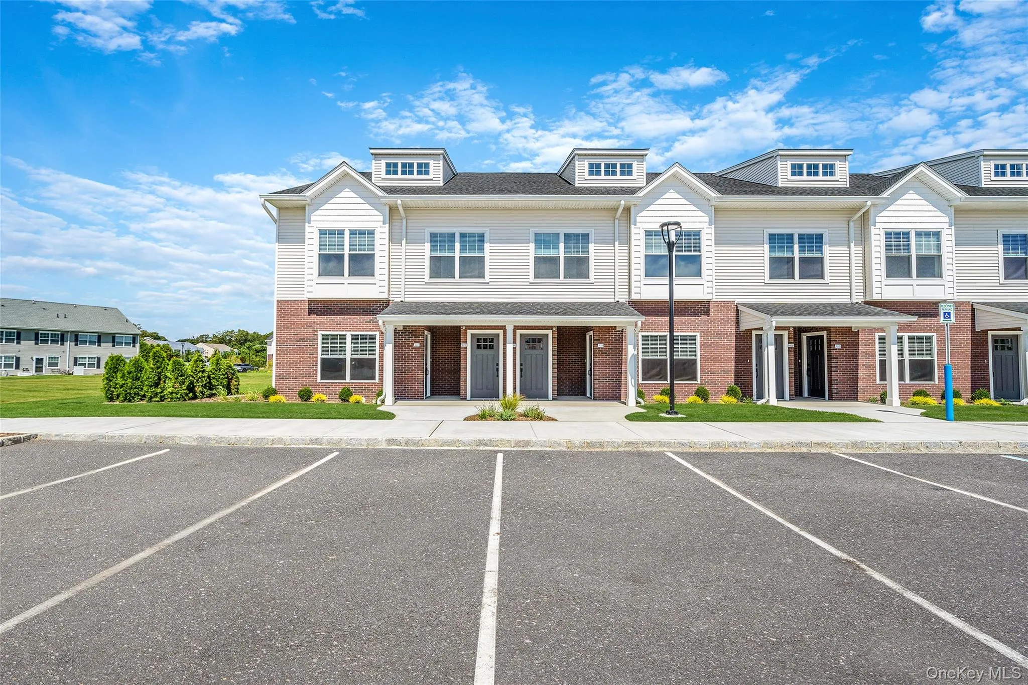 Traditional-style home with uncovered parking and brick siding Traditional-style home with uncovered parking and brick siding