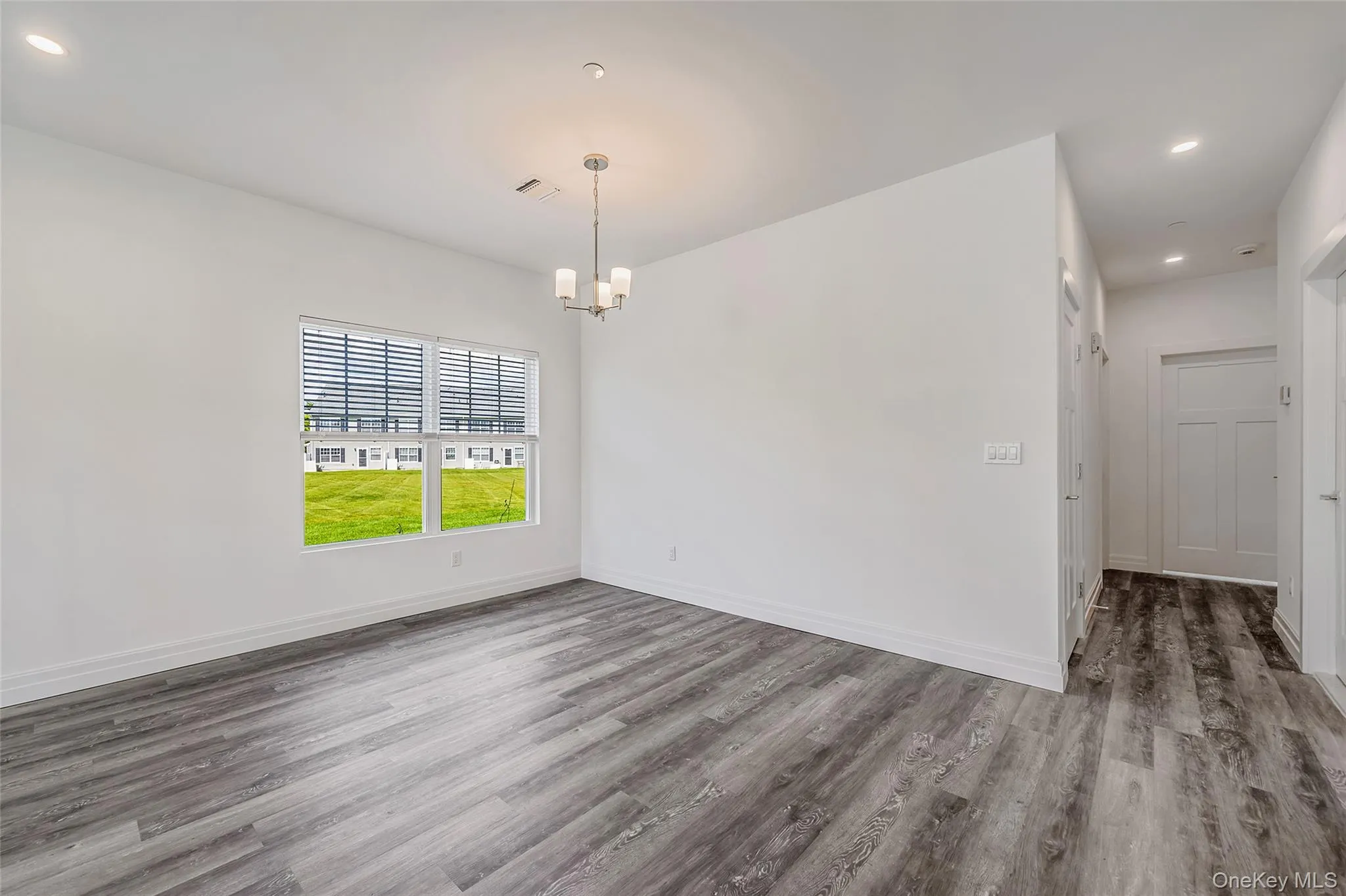 Spare room with recessed lighting, wood finished floors, and a chandelier Spare room with recessed lighting, wood finished floors, and a chandelier