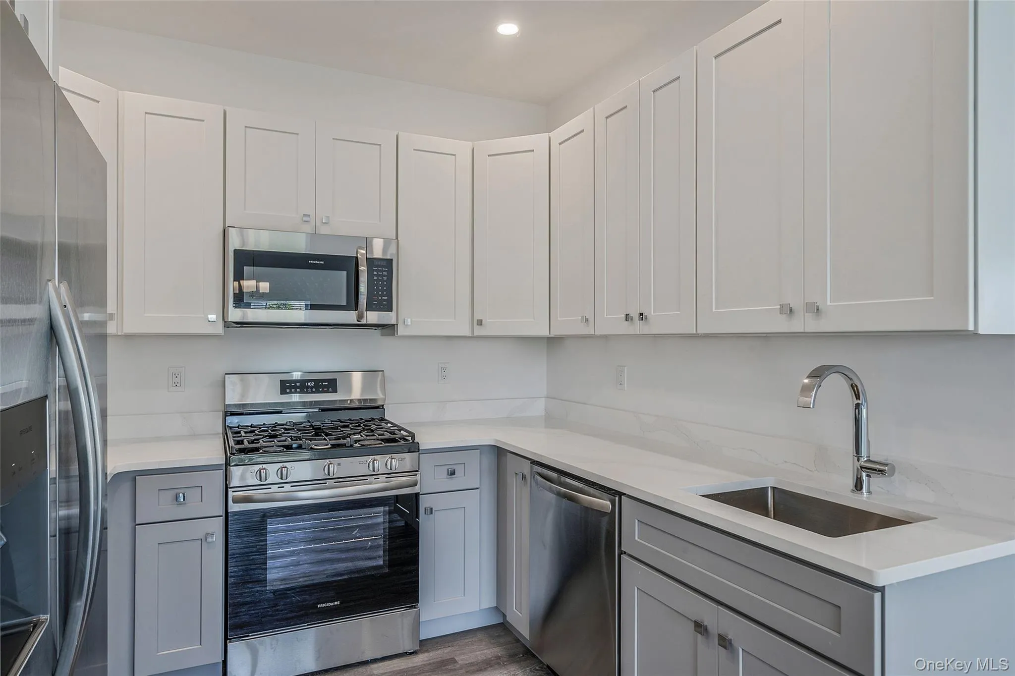 Kitchen featuring stainless steel appliances, gray cabinets, light stone countertops, white cabinetry, and recessed lighting Kitchen featuring stainless steel appliances, gray cabinets, light stone countertops, white cabinetry, and recessed lighting