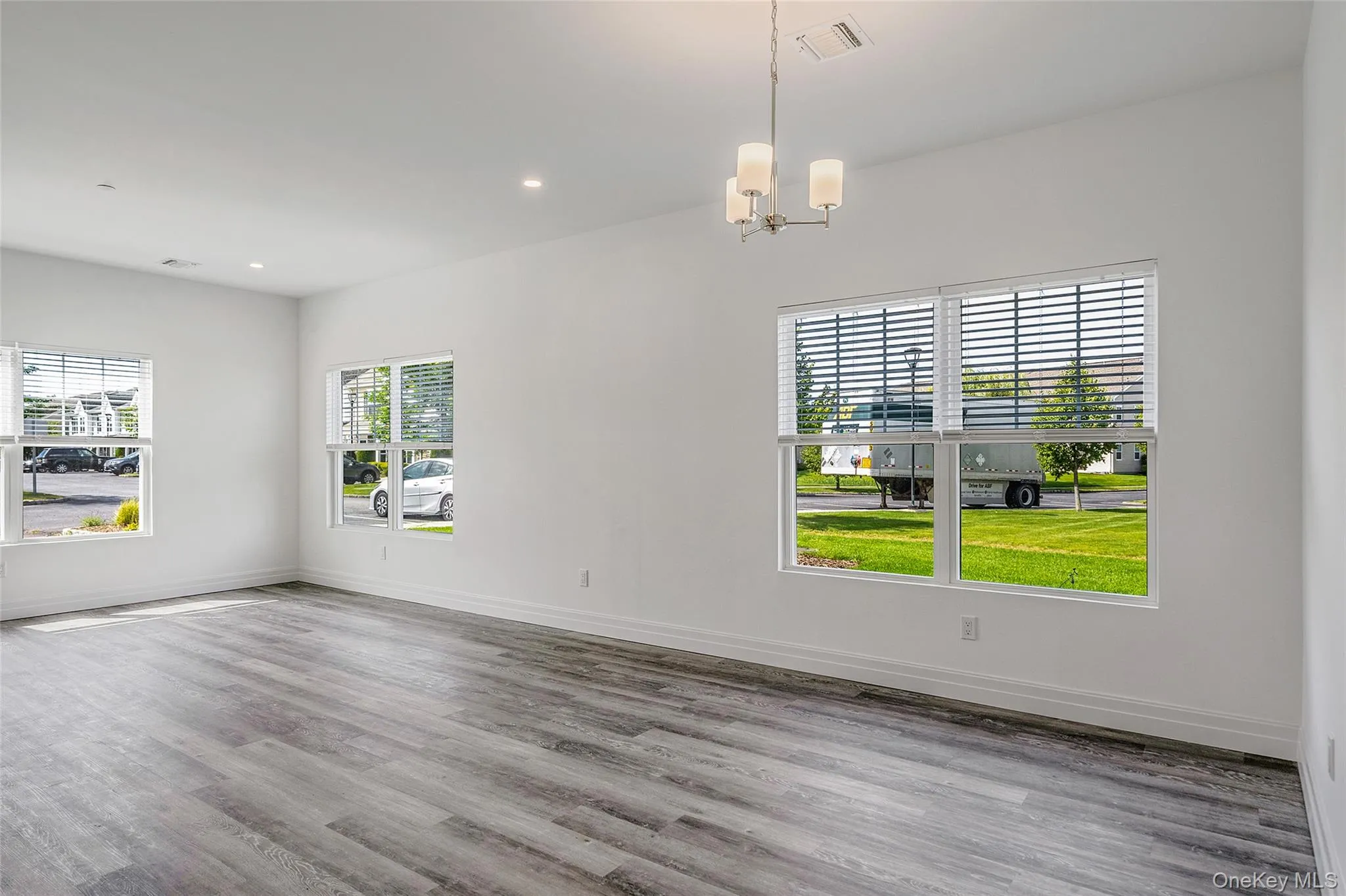 Unfurnished dining area featuring light wood-style floors, recessed lighting, and a chandelier Unfurnished dining area featuring light wood-style floors, recessed lighting, and a chandelier