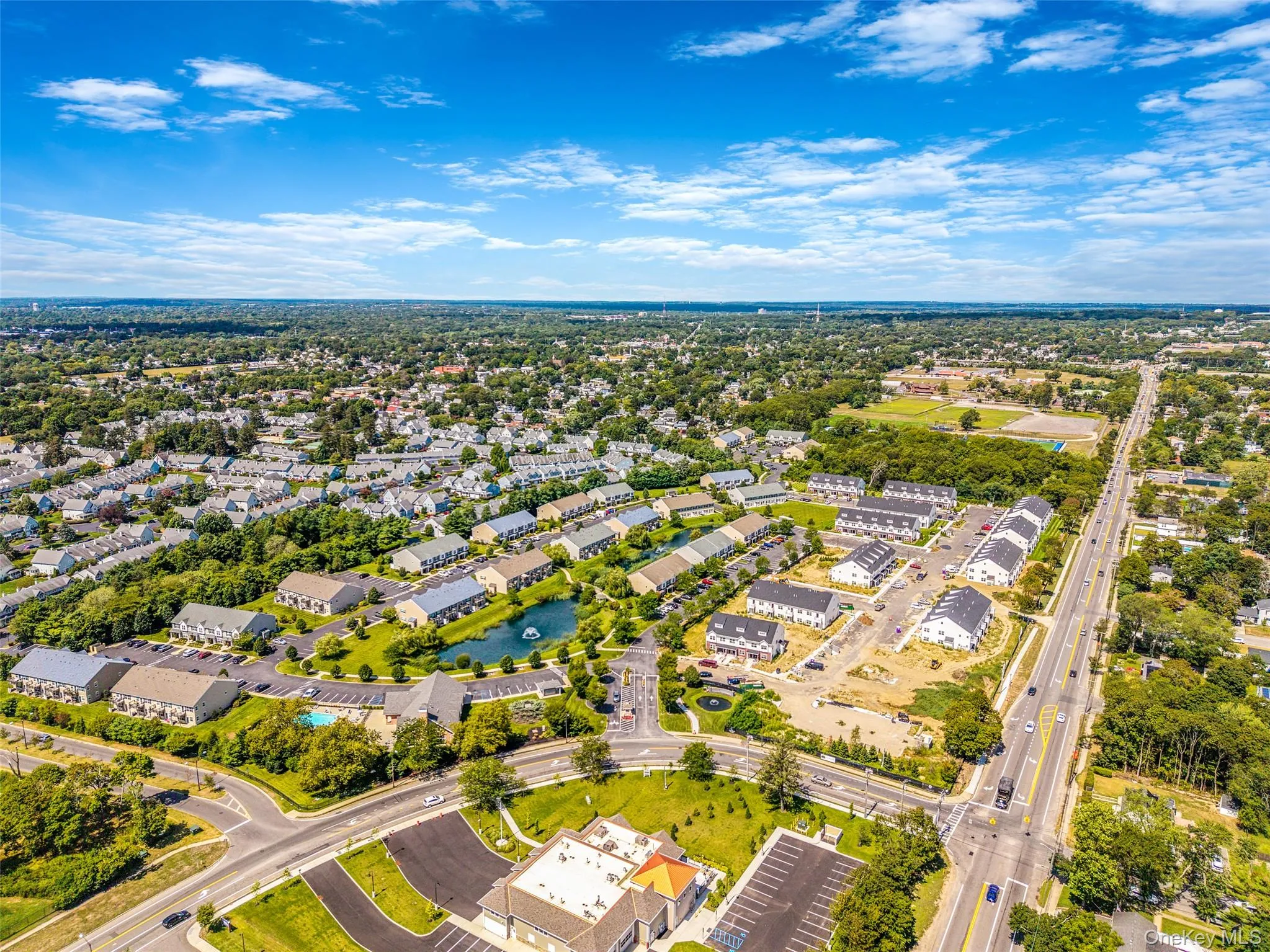 Aerial view of residential area featuring a nearby body of water and a tree filled landscape Aerial view of residential area featuring a nearby body of water and a tree filled landscape