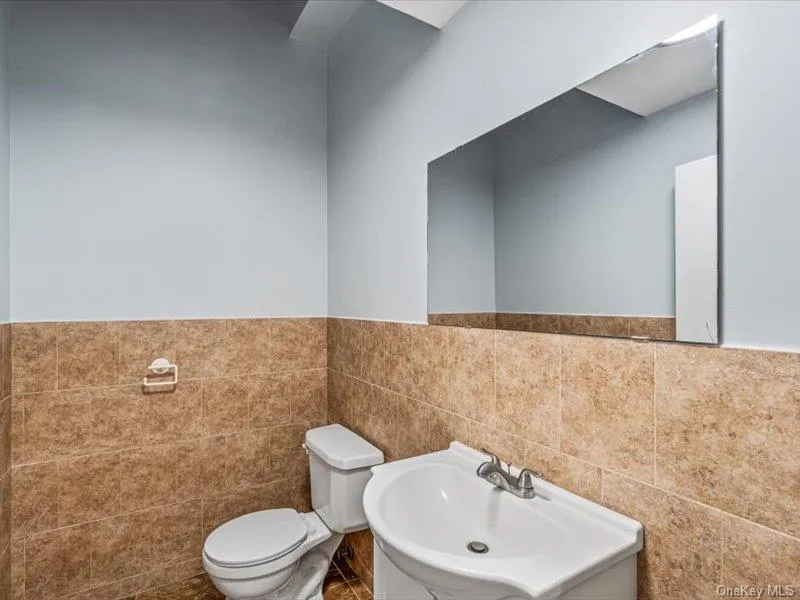 Bathroom featuring a wainscoted wall and tile walls Bathroom featuring a wainscoted wall and tile walls