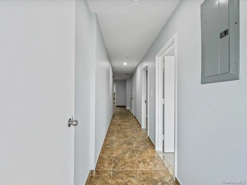 Hall featuring electric panel, recessed lighting, and stone finish floors Hall featuring electric panel, recessed lighting, and stone finish floors