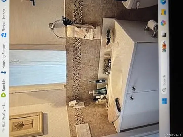 Half bath featuring vanity and tasteful backsplash Half bath featuring vanity and tasteful backsplash