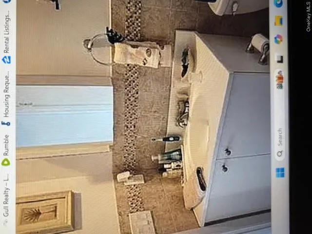 Half bath featuring vanity and tasteful backsplash Half bath featuring vanity and tasteful backsplash