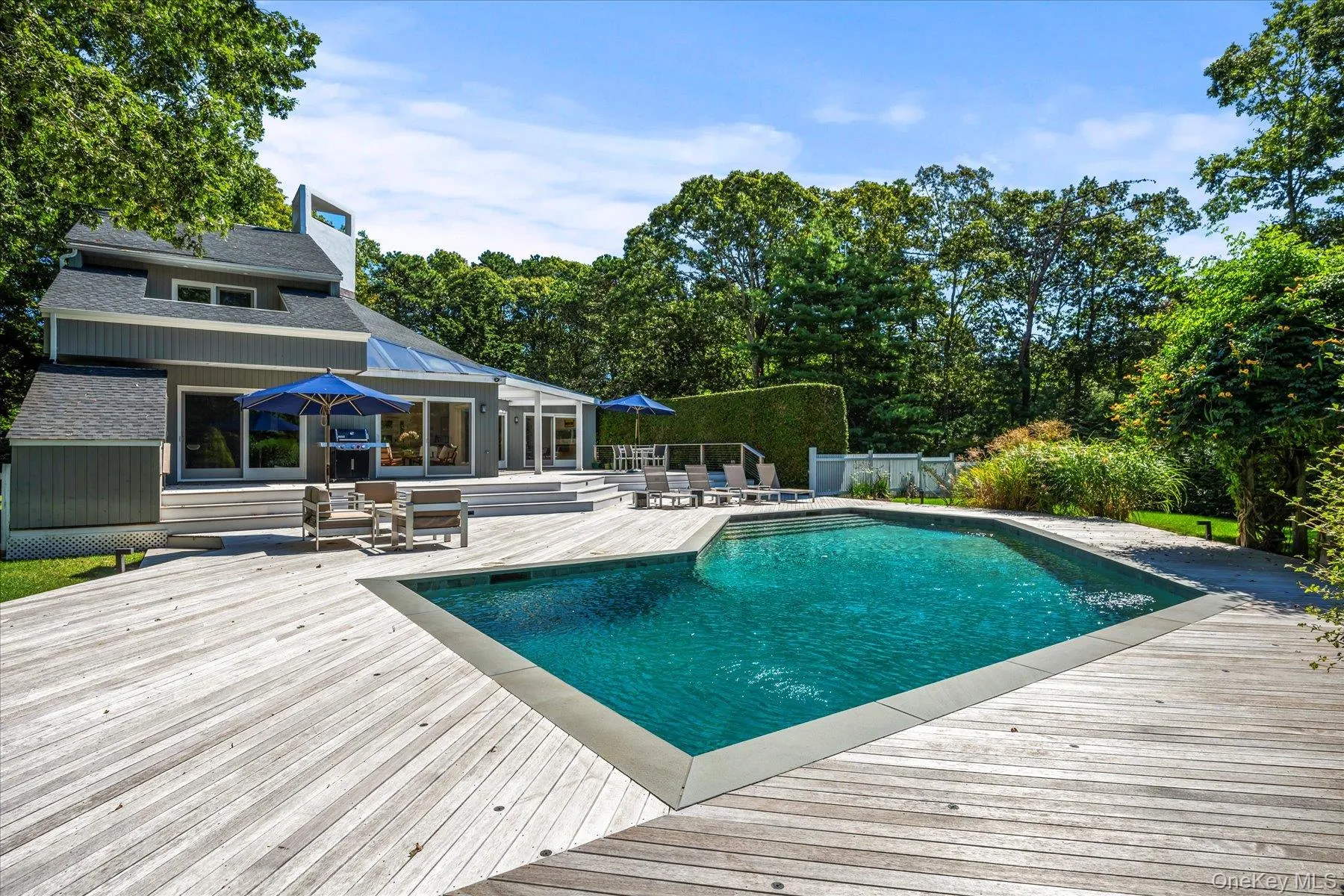 Swimming pool featuring a wooden deck and home Swimming pool featuring a wooden deck and home