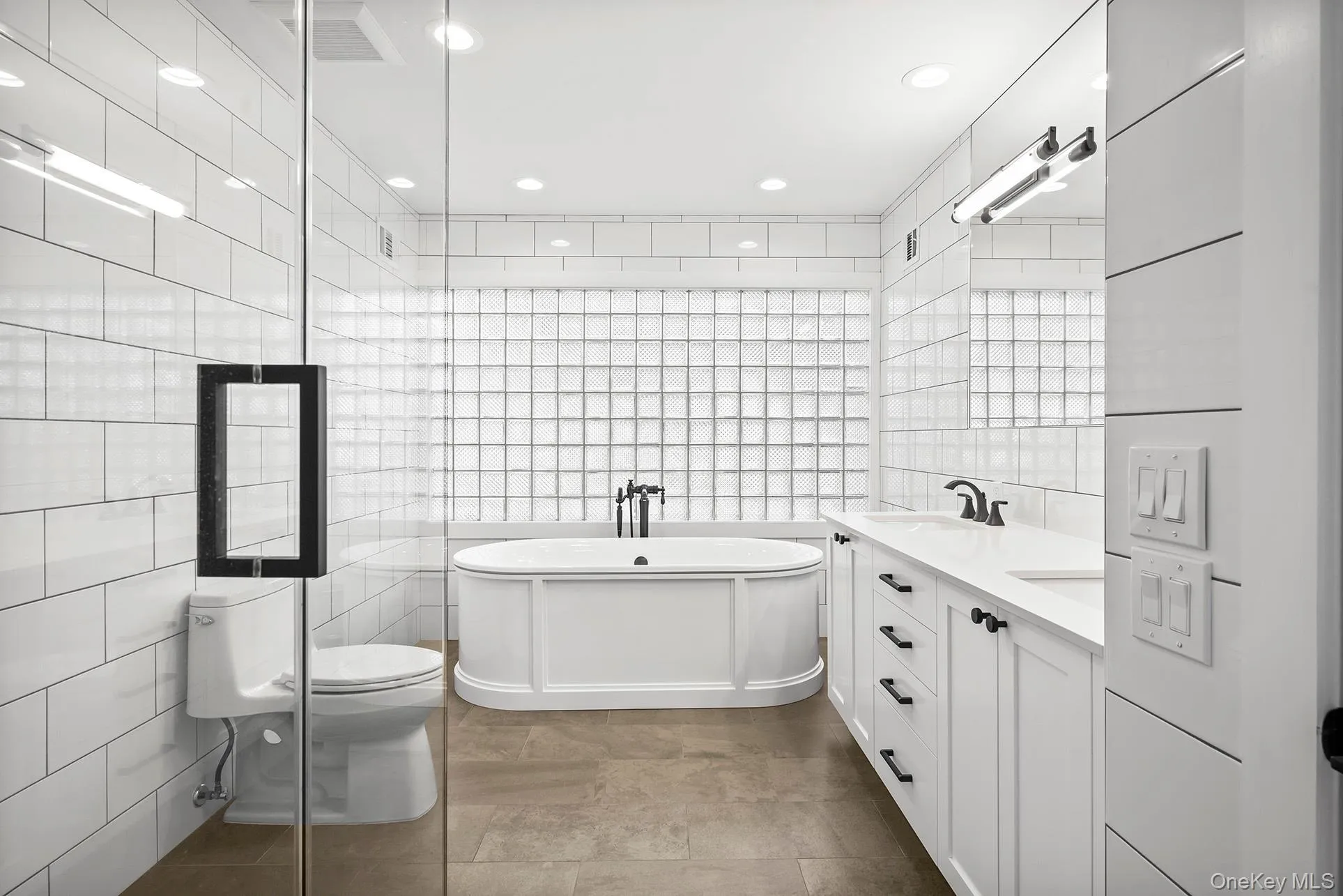 Primary full bath with tile walls, double vanity, a soaking tub Primary full bath with tile walls, double vanity, a soaking tub