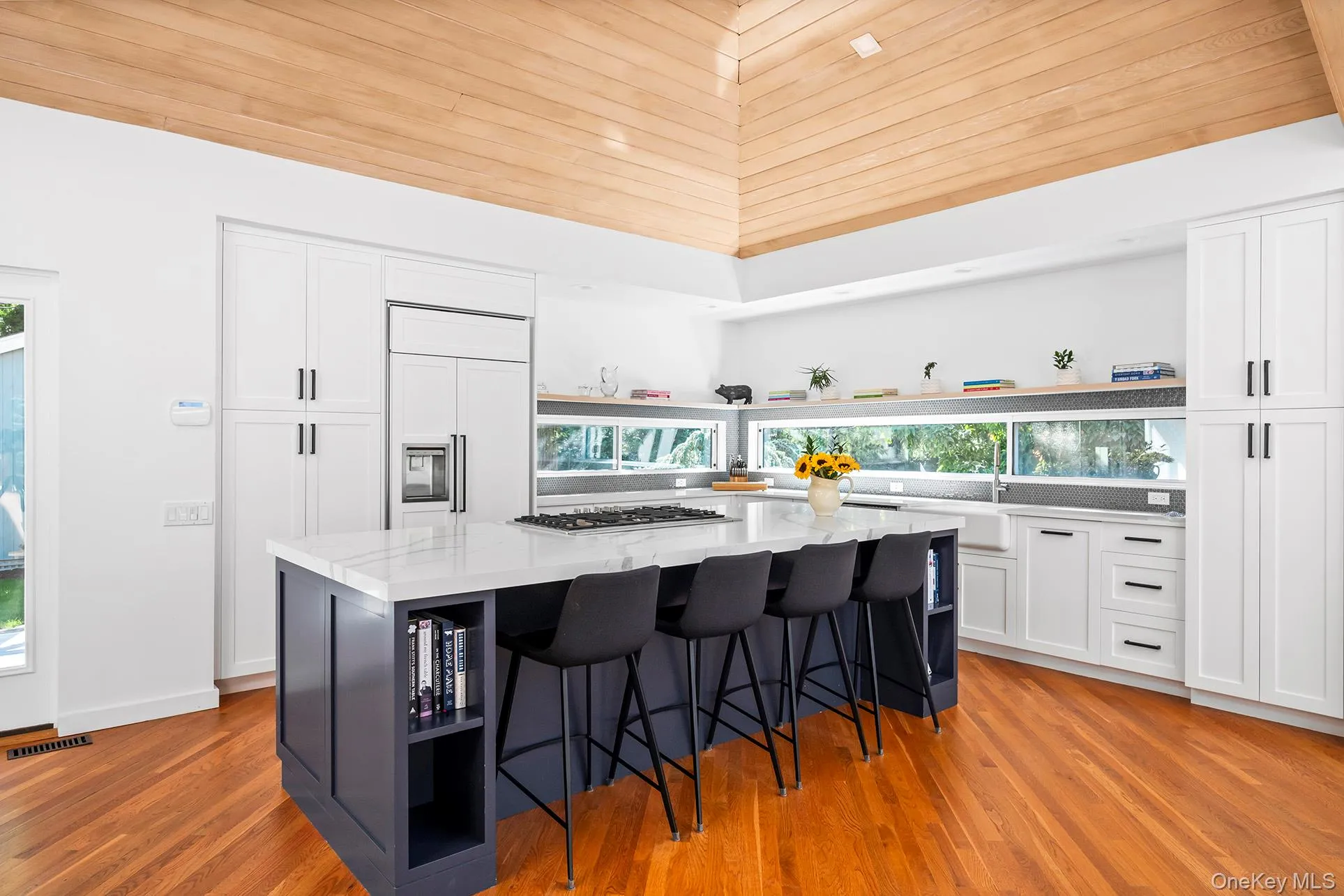 Kitchen featuring open shelves, a breakfast bar area, white cabinets, a spacious island, and wooden ceiling Kitchen featuring open shelves, a breakfast bar area, white cabinets, a spacious island, and wooden ceiling