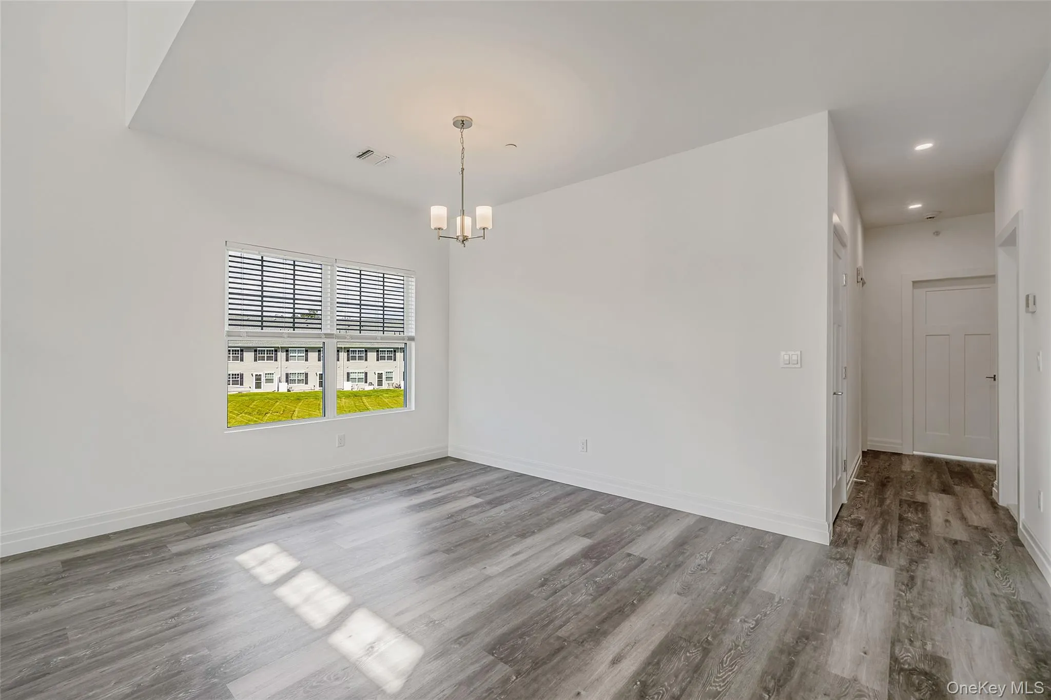 Unfurnished dining area featuring light wood finished floors and a chandelier Unfurnished dining area featuring light wood finished floors and a chandelier