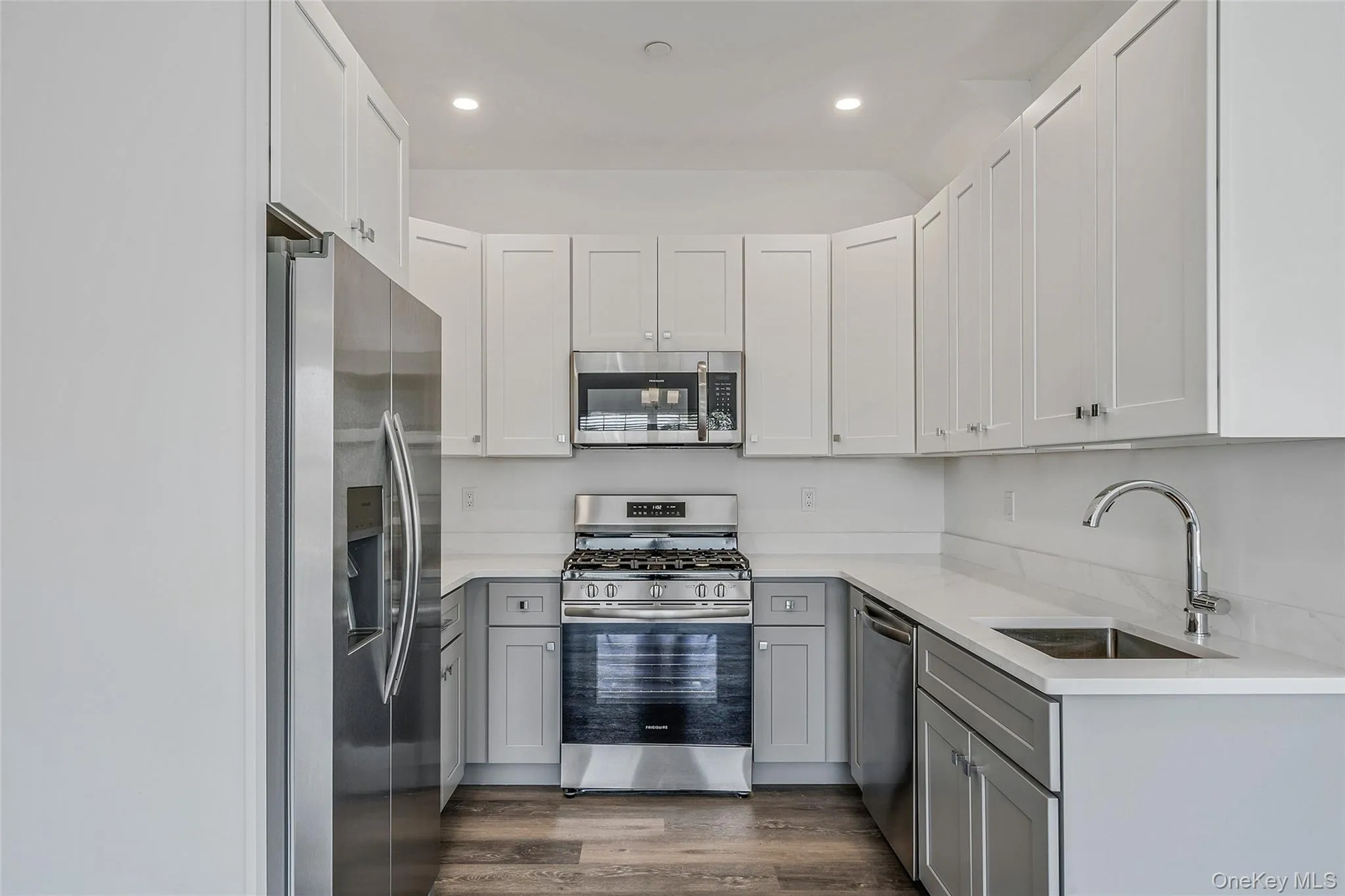 Kitchen with gray cabinets, appliances with stainless steel finishes, white cabinets, light stone counters, and recessed lighting Kitchen with gray cabinets, appliances with stainless steel finishes, white cabinets, light stone counters, and recessed lighting