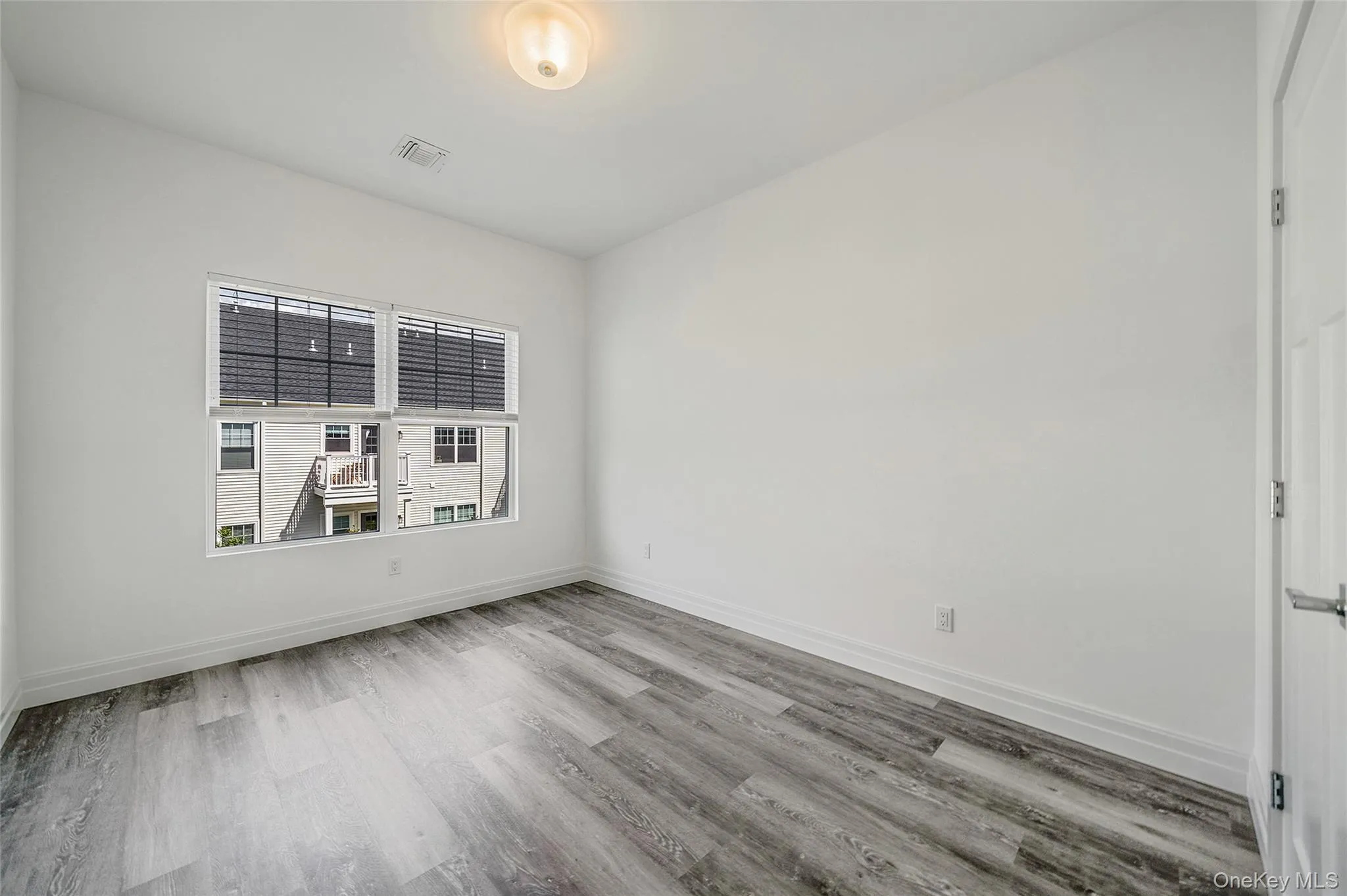Spare room featuring light wood-type flooring and baseboards Spare room featuring light wood-type flooring and baseboards